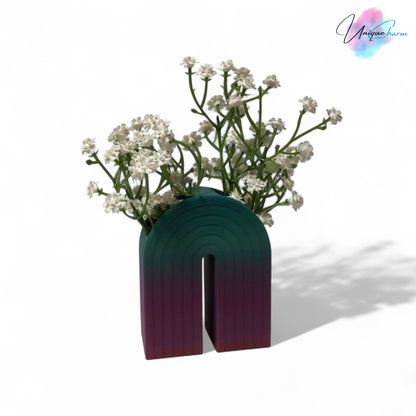 Colorful 3D printed rainbow-shaped organizer used as a bookend, pen holder, and mini vase, displayed in two sizes on a shelf with books, stationery, and dried flowers.