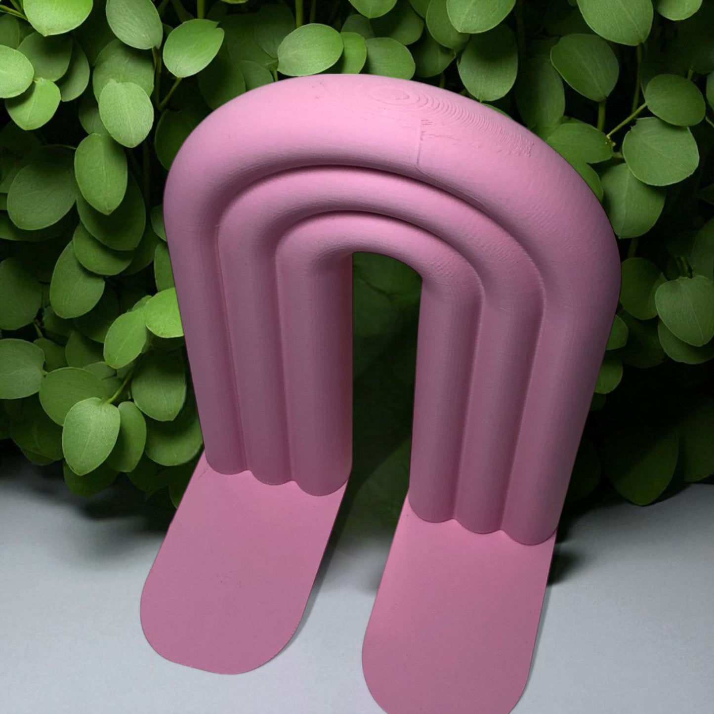 single-piece rainbow arch bookend in colorful design, displayed on a shelf holding books upright. ideal for nurseries, kids' rooms, and modern home decor.