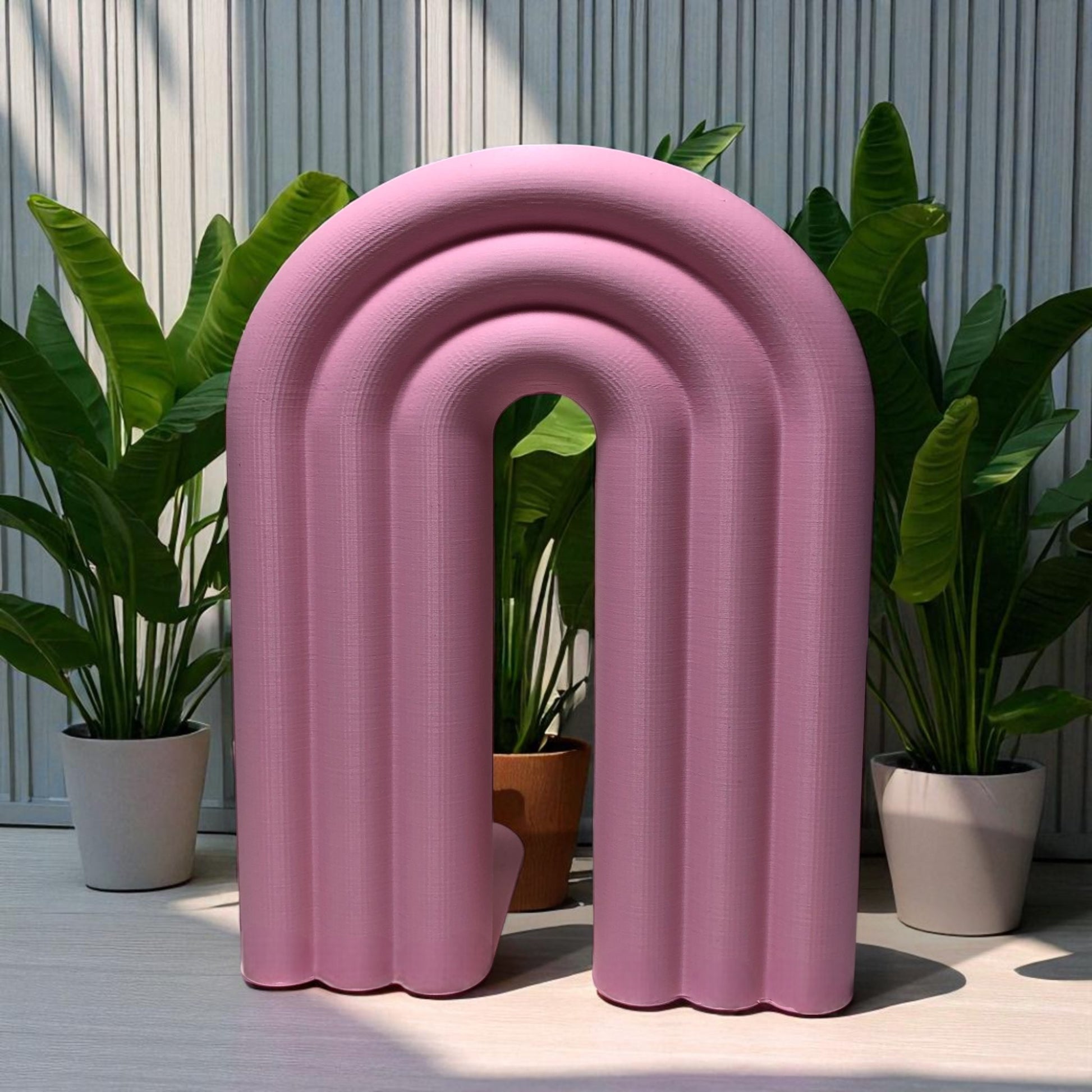 Single-piece rainbow arch bookend in colorful design, displayed on a shelf holding books upright. Ideal for nurseries, kids' rooms, and modern home decor.
