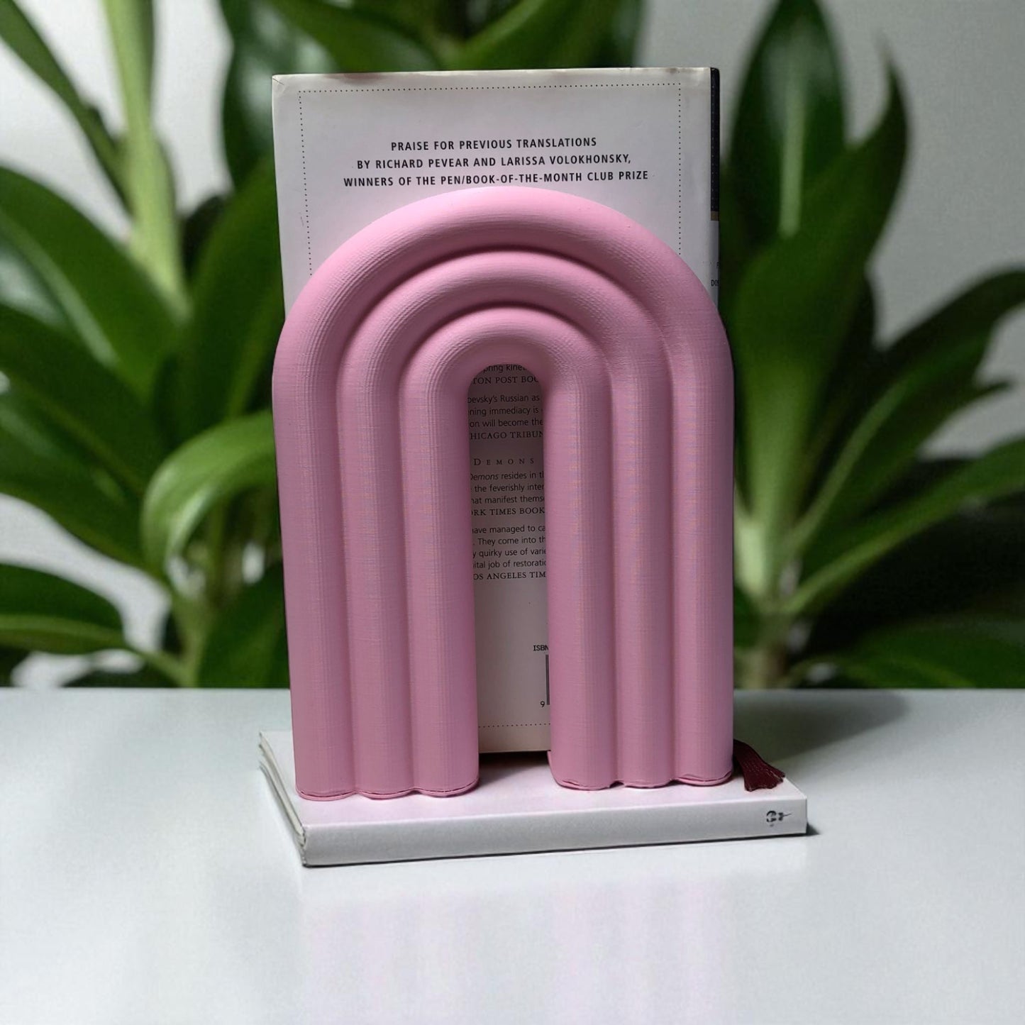 single-piece rainbow arch bookend in colorful design, displayed on a shelf holding books upright. ideal for nurseries, kids' rooms, and modern home decor.