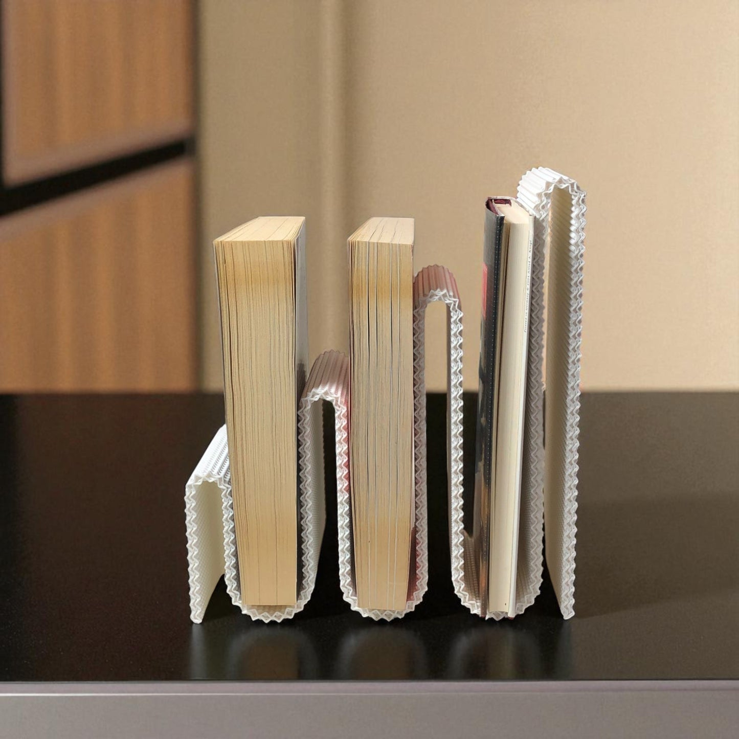 modern wavy book stand in textured white, holding two books upright; perfect for organizing books, magazines, or vinyls on a desk, shelf, or reading nook