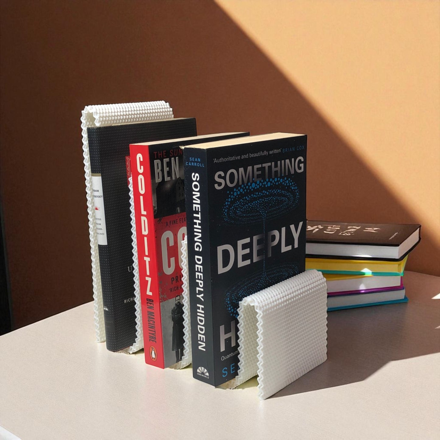modern wavy book stand in textured white, holding two books upright; perfect for organizing books, magazines, or vinyls on a desk, shelf, or reading nook