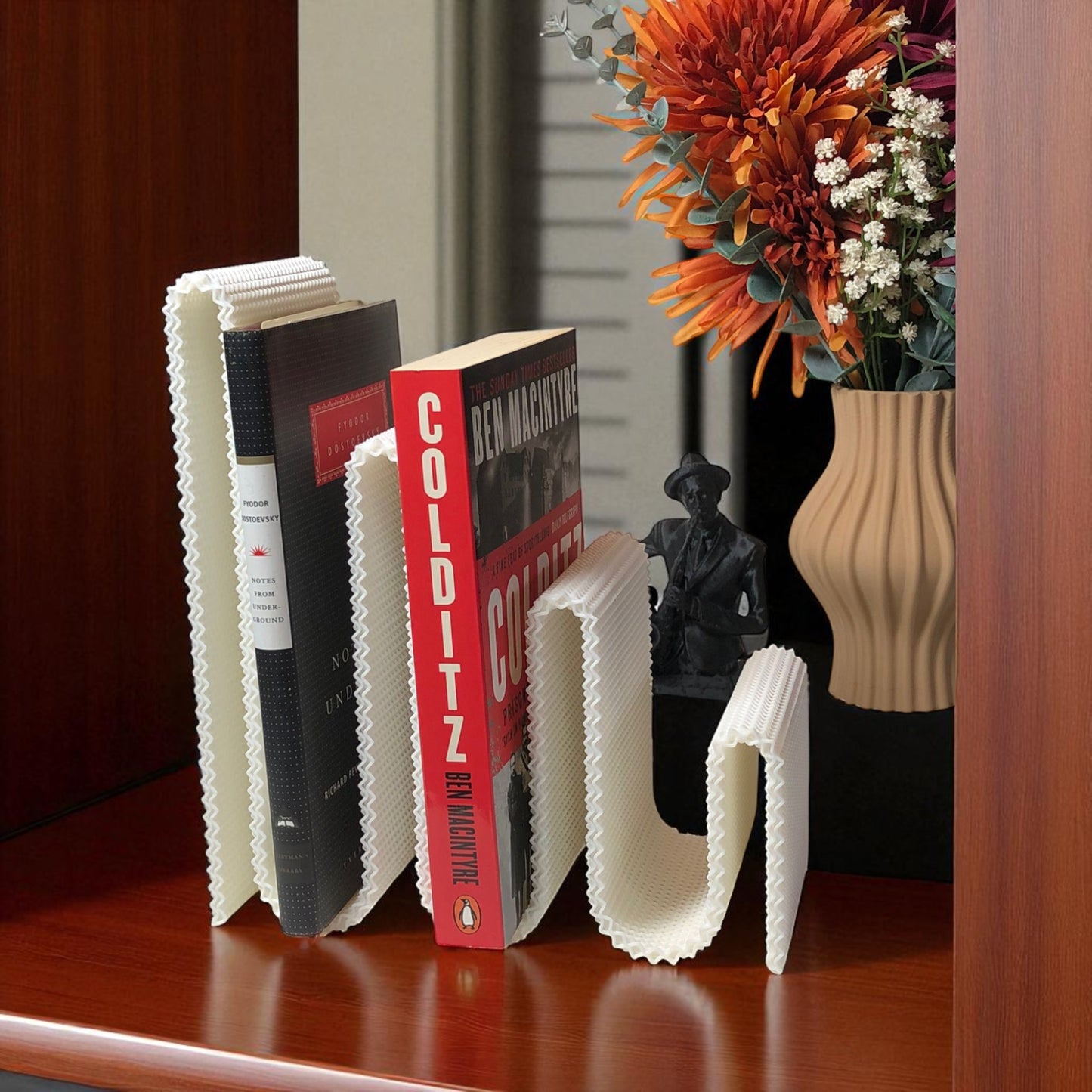 modern wavy book stand in textured white, holding two books upright; perfect for organizing books, magazines, or vinyls on a desk, shelf, or reading nook
