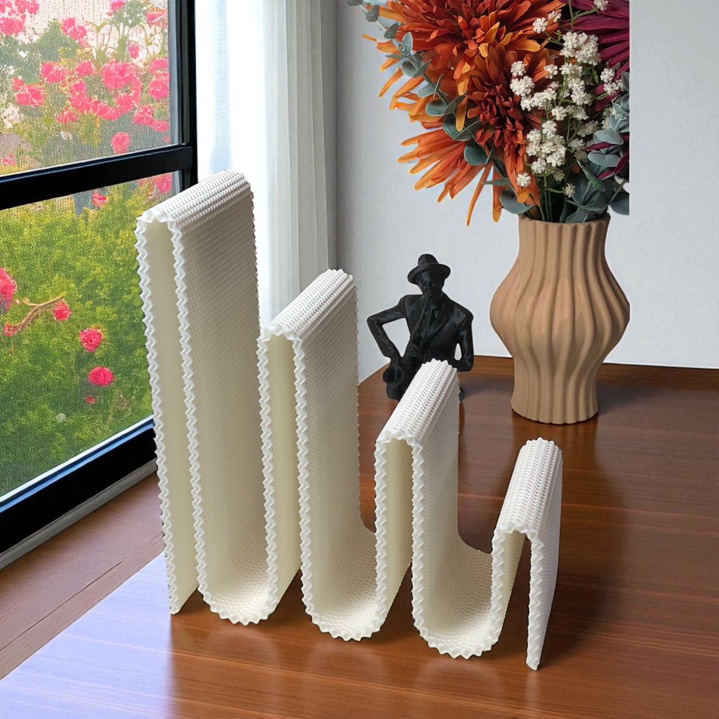 modern wavy book stand in textured white, holding two books upright; perfect for organizing books, magazines, or vinyls on a desk, shelf, or reading nook