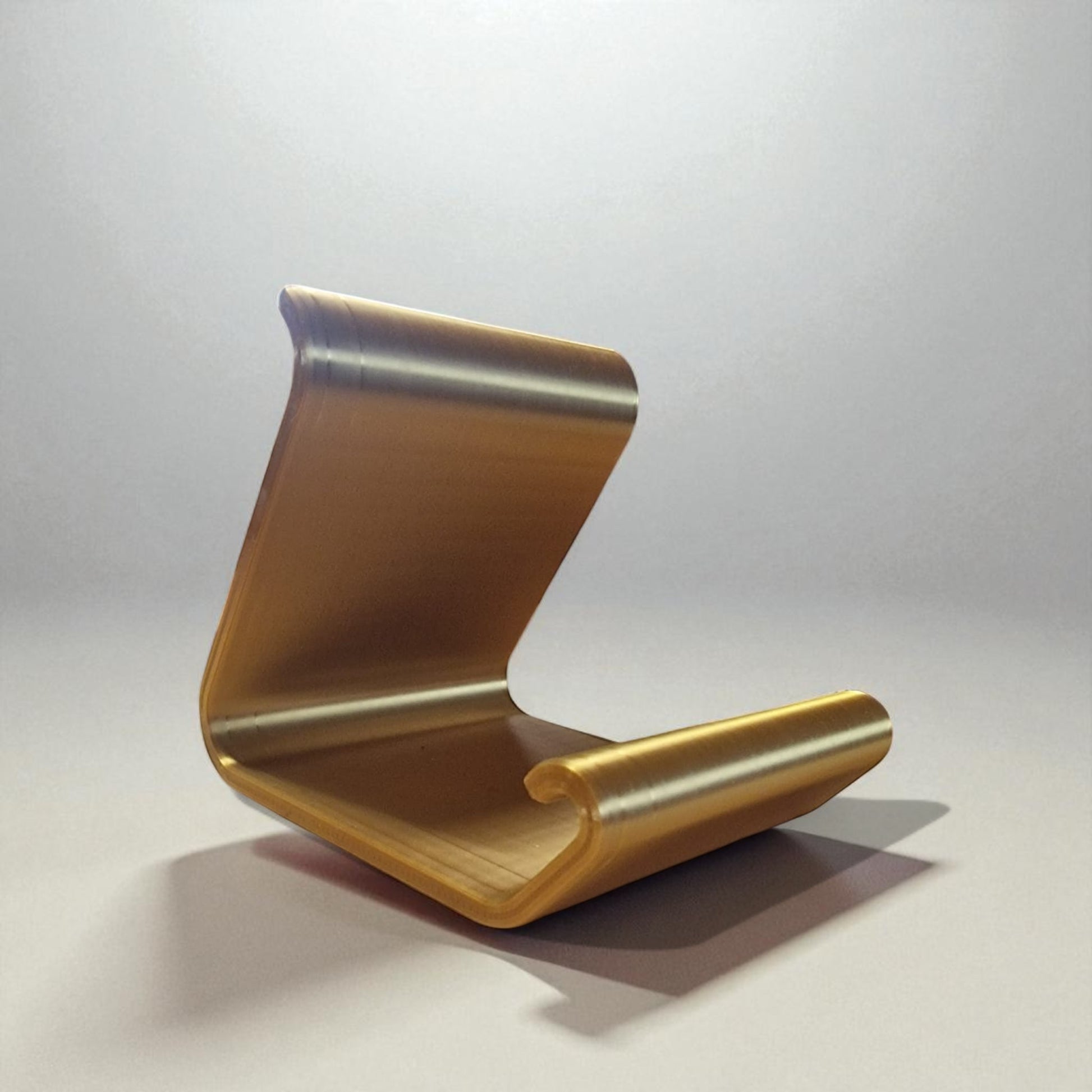 Ergonomic phone holder made of durable 3D-printed material, designed with a sleek and modern look. It securely holds your phone at an optimal angle for comfortable viewing, making it perfect for desks, nightstands, or kitchen counters. Compact, stylish, and practical for everyday use