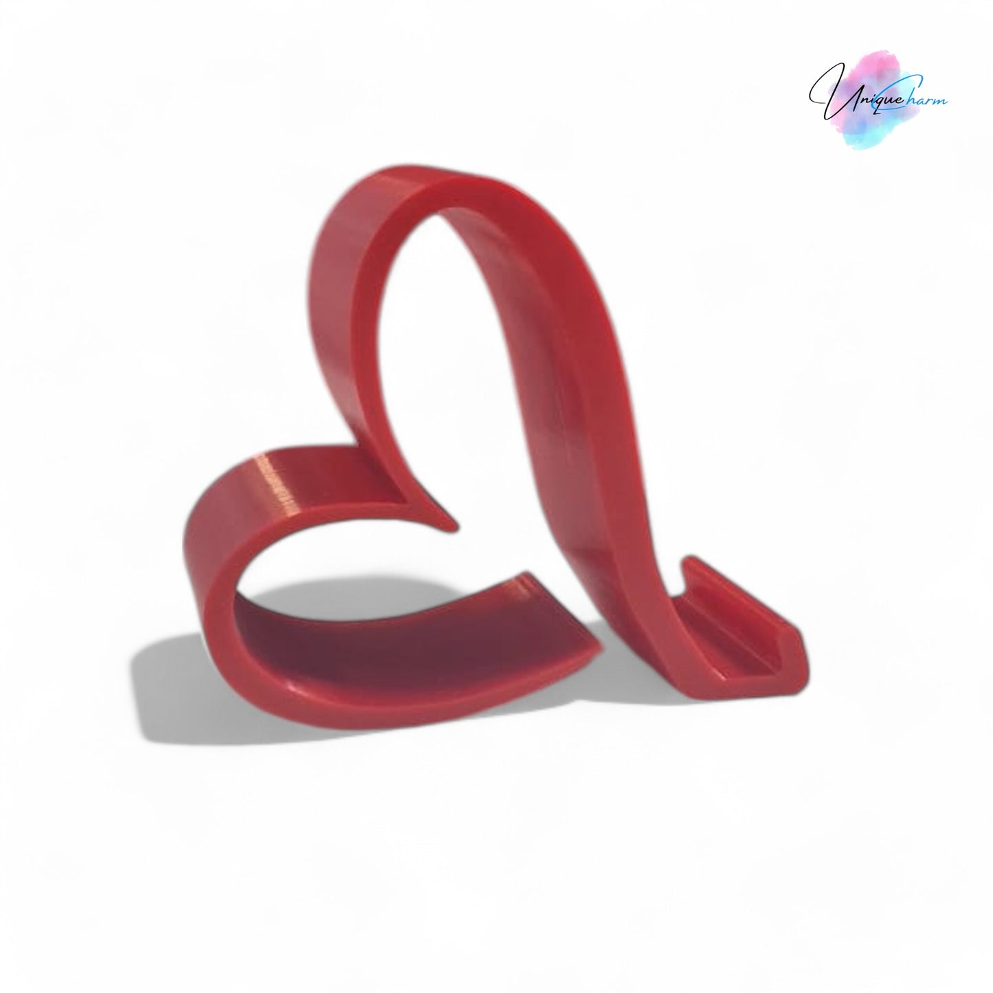 heart-shaped universal phone and kindle holder in an elegant design, securely holding a smartphone on a desk. stylish and versatile stand suitable for all phones, kindles, and small tablets, perfect for hands-free viewing