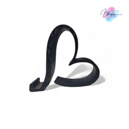 Heart-shaped universal phone and Kindle holder in an elegant design, securely holding a smartphone on a desk. Stylish and versatile stand suitable for all phones, Kindles, and small tablets, perfect for hands-free viewing