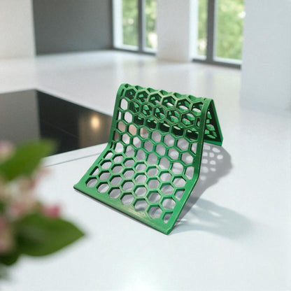Honeycomb Stand: A versatile and stylish stand with a honeycomb pattern, designed to hold phones, tablets, and Kindles securely at an optimal viewing angle, blending functionality with modern design.
