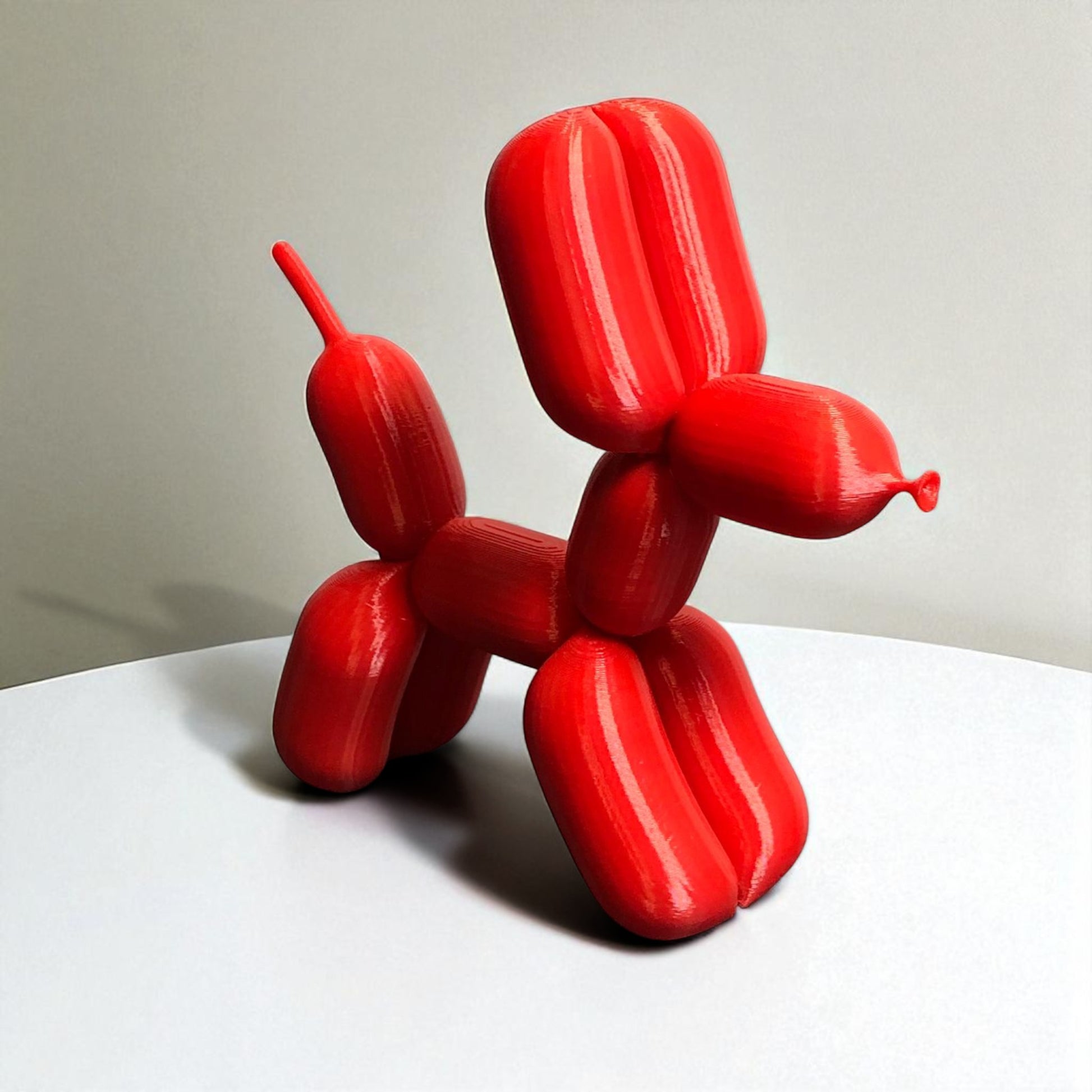 3D-printed figurine resembling a playful dog made from balloons, available in three different sizes. Perfect for home decor, kids' rooms, or as a unique gift for dog lovers.