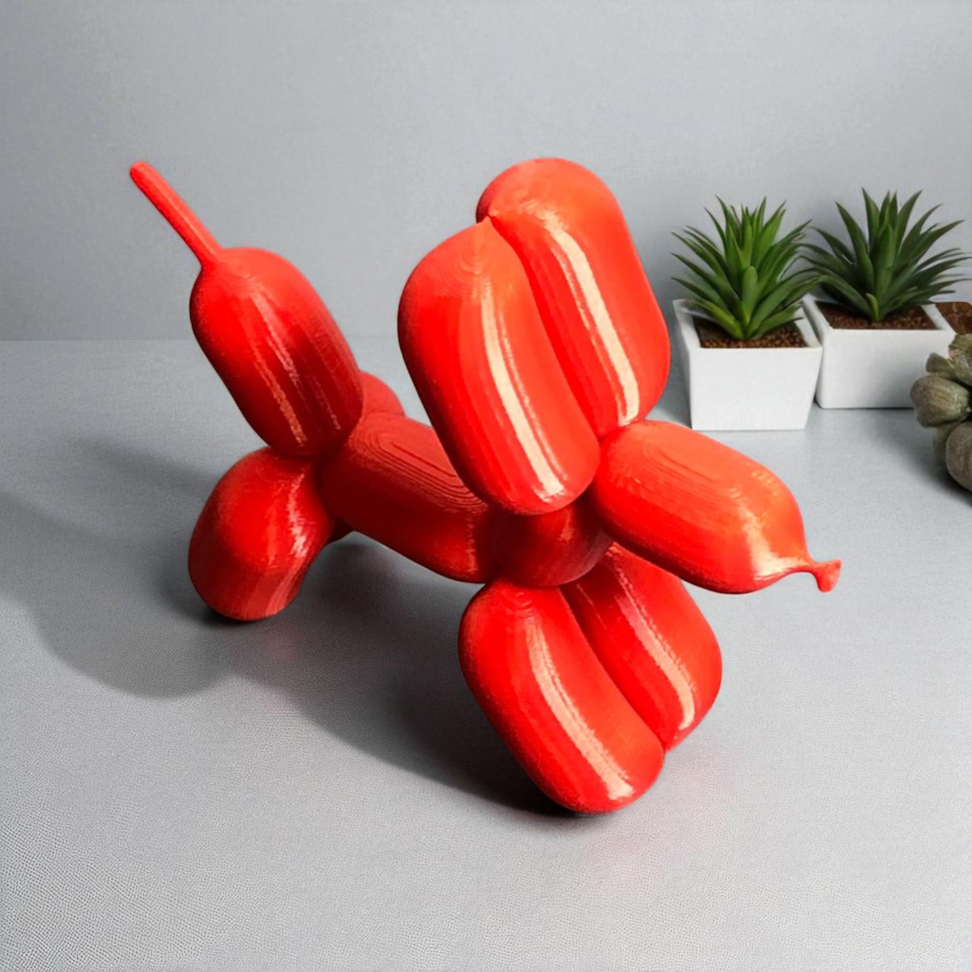 3D-printed figurine resembling a playful dog made from balloons, available in three different sizes. Perfect for home decor, kids' rooms, or as a unique gift for dog lovers.