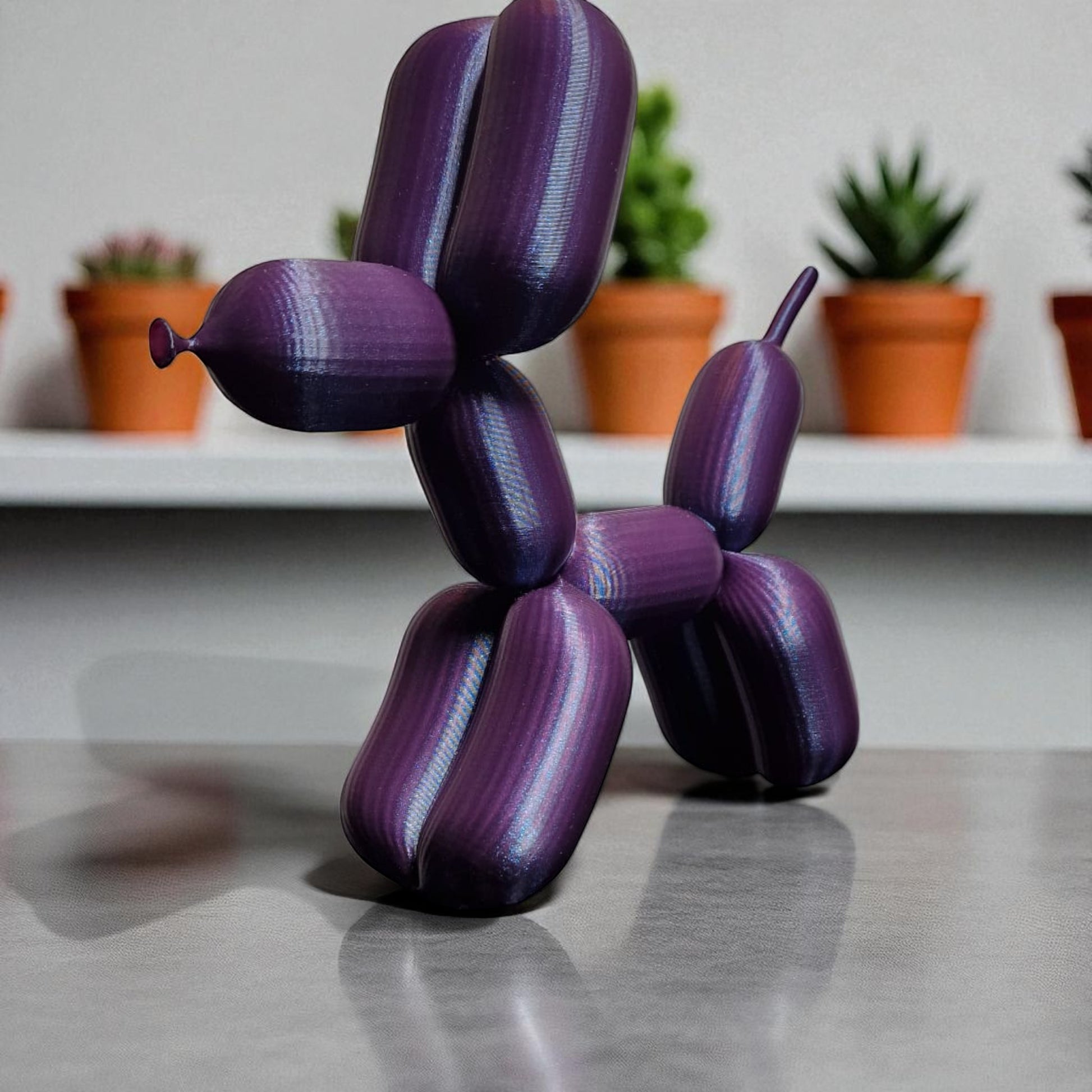 3D-printed figurine resembling a playful dog made from balloons, available in three different sizes. Perfect for home decor, kids' rooms, or as a unique gift for dog lovers.