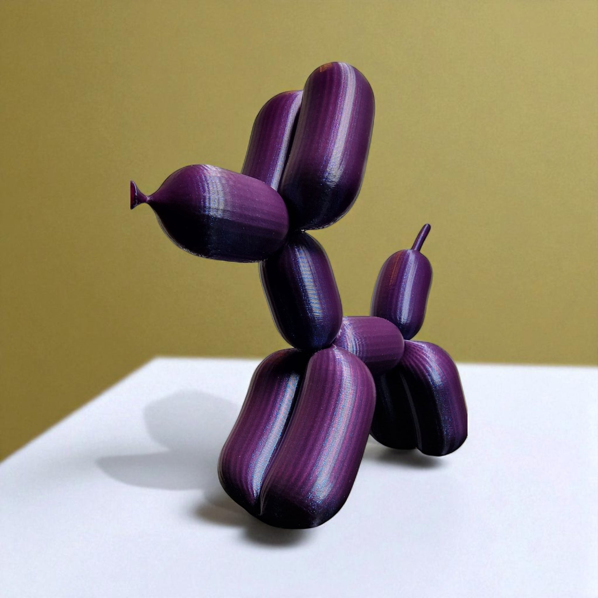 3D-printed figurine resembling a playful dog made from balloons, available in three different sizes. Perfect for home decor, kids' rooms, or as a unique gift for dog lovers.