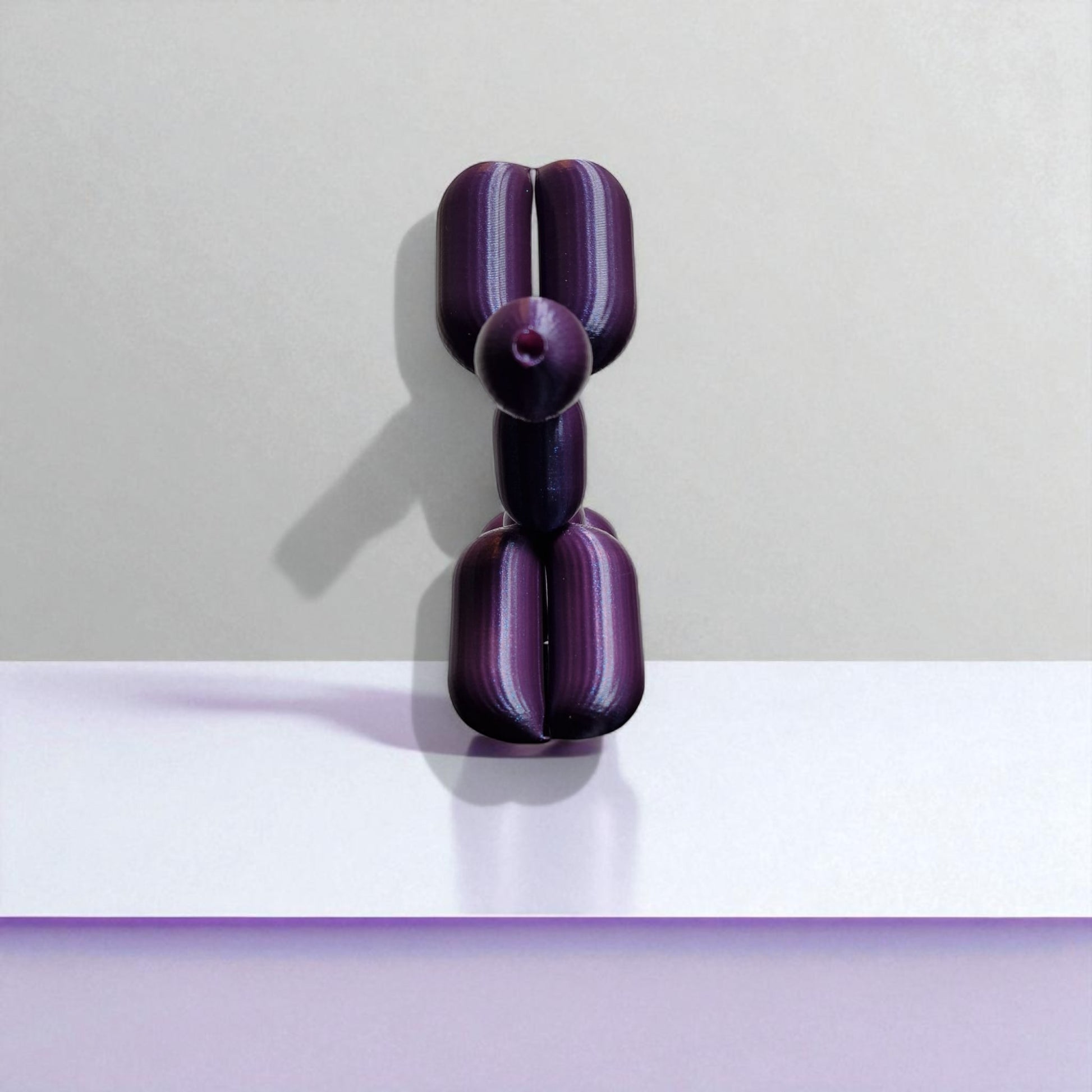 3D-printed figurine resembling a playful dog made from balloons, available in three different sizes. Perfect for home decor, kids' rooms, or as a unique gift for dog lovers.