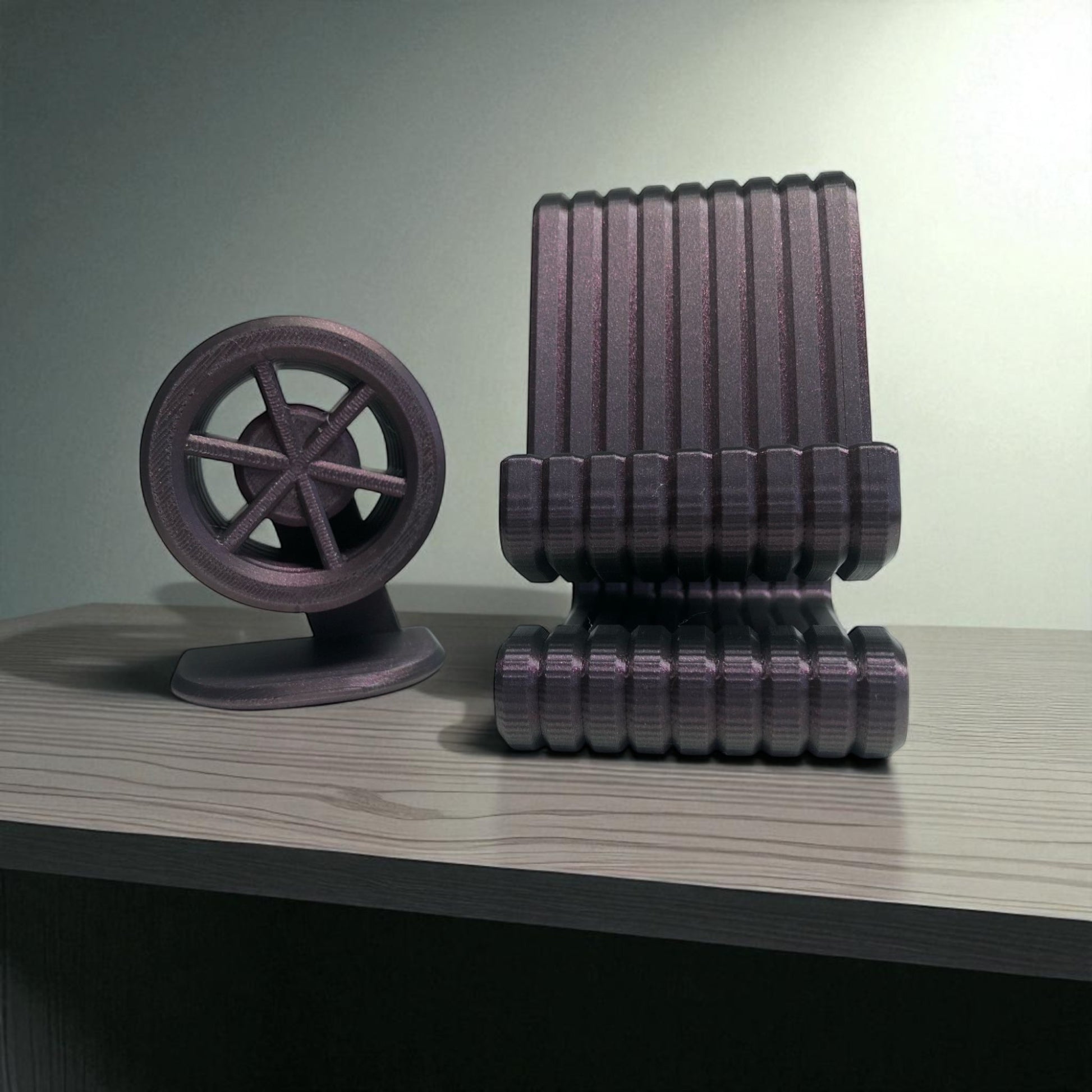 3D-printed model of a chair and wheel on a wooden surface with a neutral background