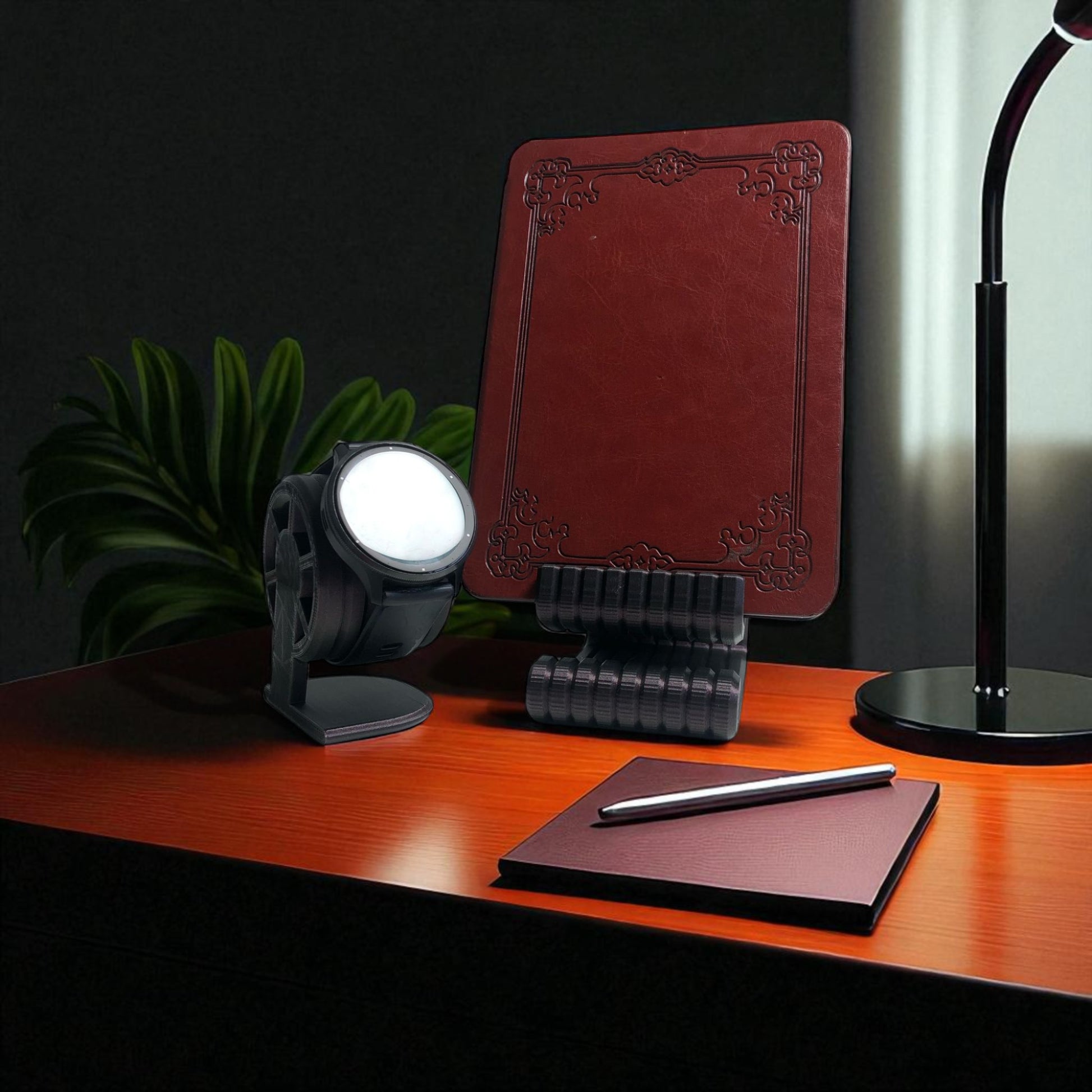 Desk setup with a red notebook, pen, and decorative items on a wooden surface.
