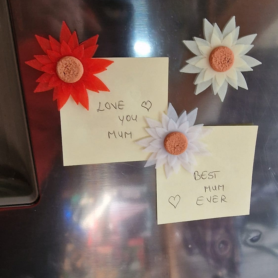 Two notes with floral decorations on a metallic surface