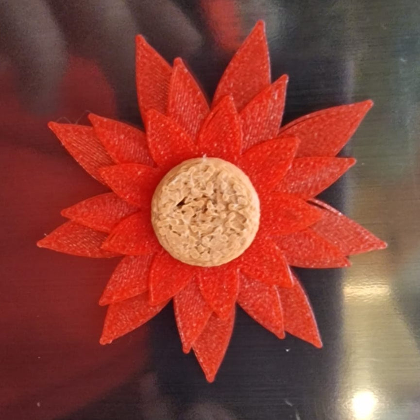 Red flower-shaped object on a reflective surface with blurred background
