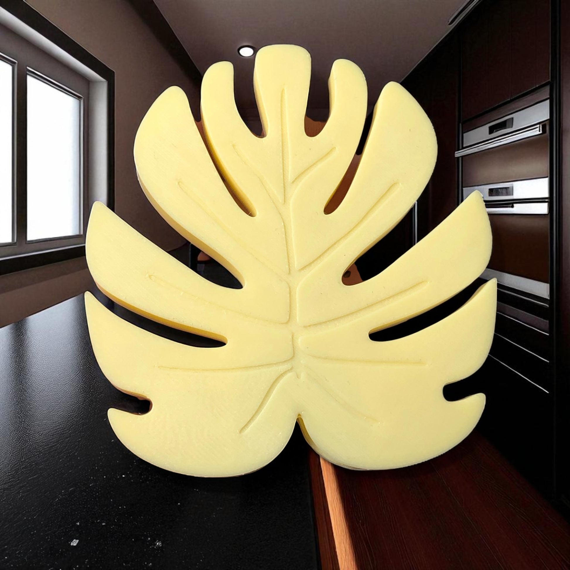 Yellow leaf-shaped object on a dark surface with a blurred indoor background