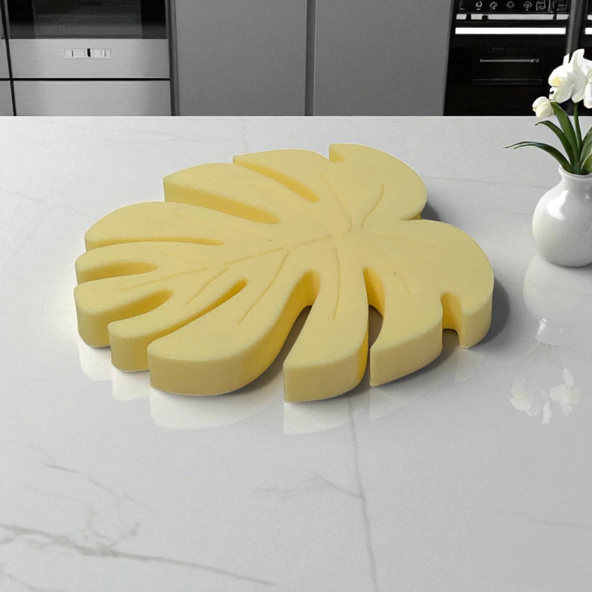 Yellow leaf-shaped cutting board on a kitchen counter