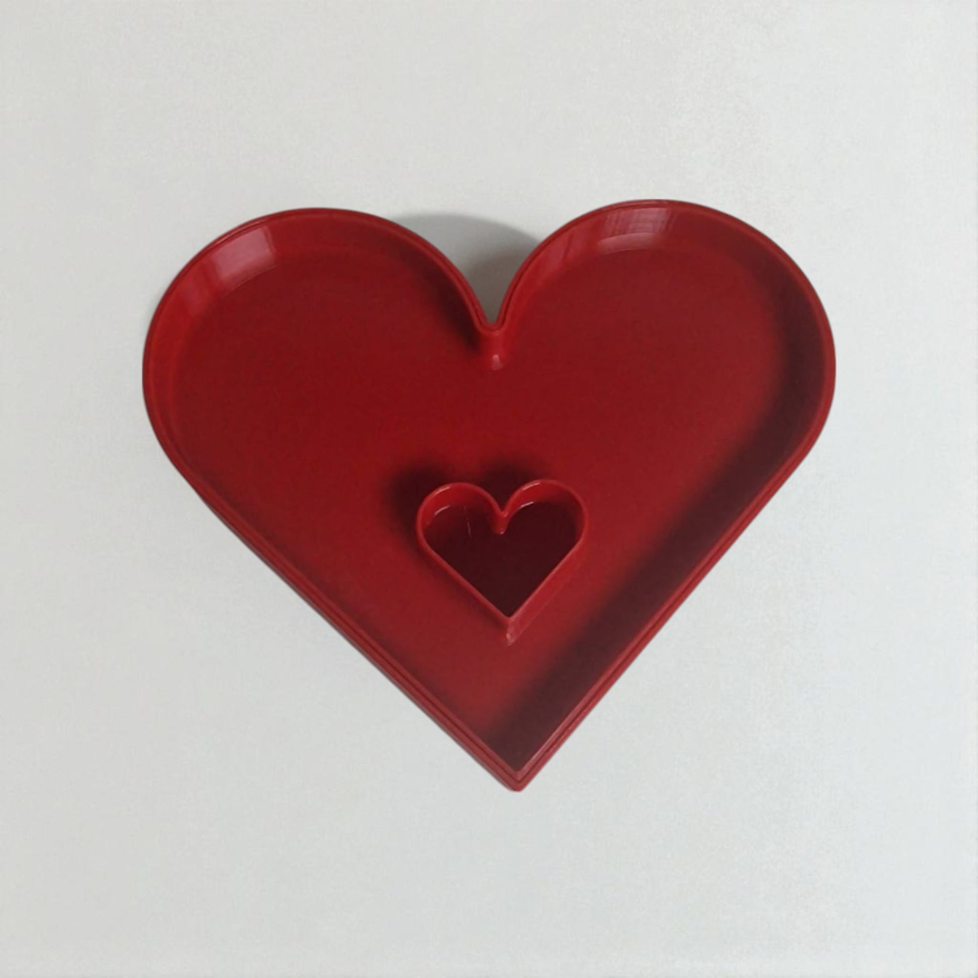 Red heart-shaped object on a white background