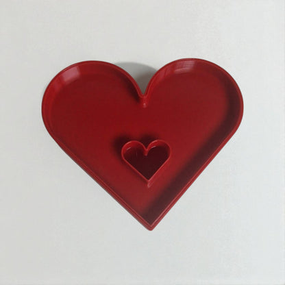 Red heart-shaped object on a white background