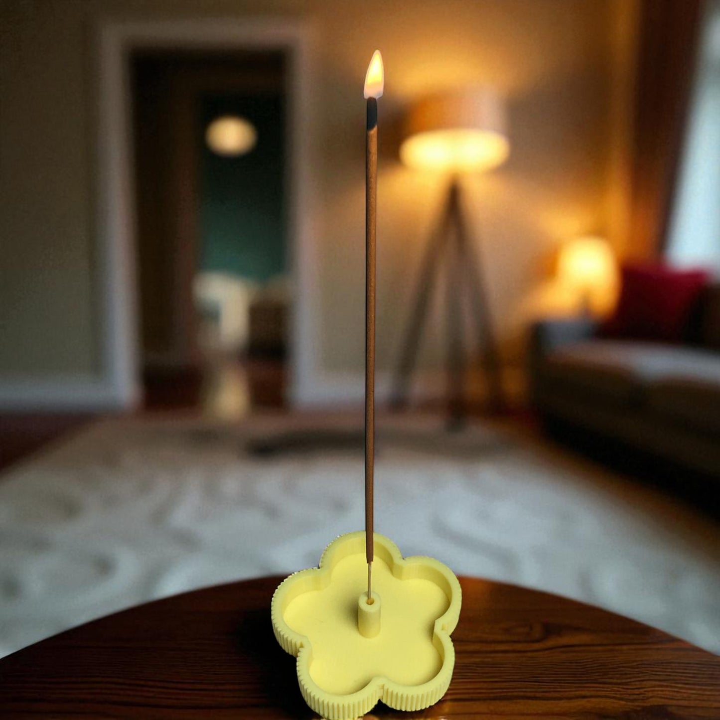 incense stick in a yellow holder on a wooden surface with a blurred indoor background