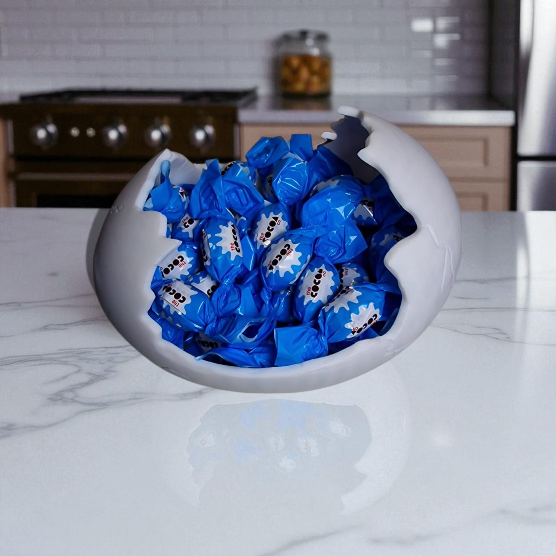 White bowl filled with blue wrapped candies on a kitchen counter