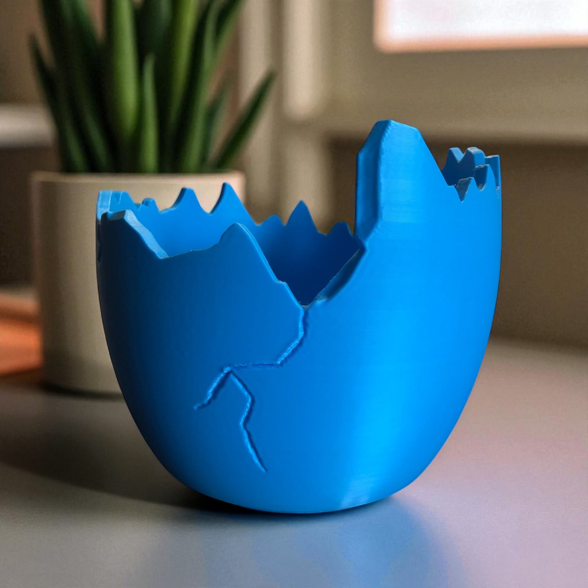 A modern cracked egg-shaped planter holding a small succulent, perfect for Easter decor and spring home styling. This unique plant pot is ideal for small to medium plants, adding a fresh and charming touch to any windowsill, desk, or shelf.