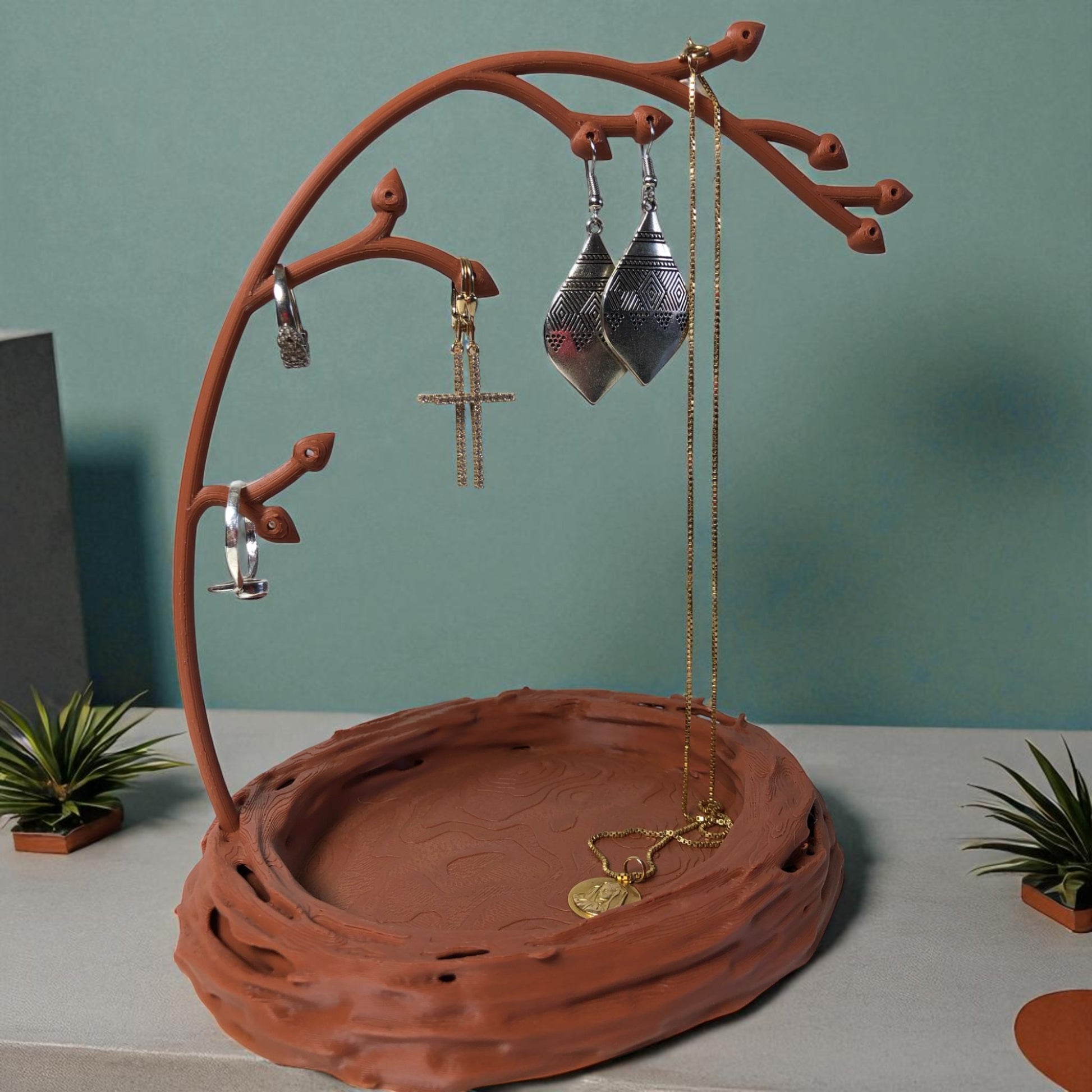A uniquely designed bird nest jewelry tray with a branch, perfect for organizing rings, earrings, necklaces, and bracelets. The nest-shaped base includes small holes for earring storage, while the branch provides an elegant spot for hanging jewelry. Made from durable, eco-friendly 3D-printed material, this nature-inspired jewelry organizer adds a stylish and functional touch to any vanity or dresser.
