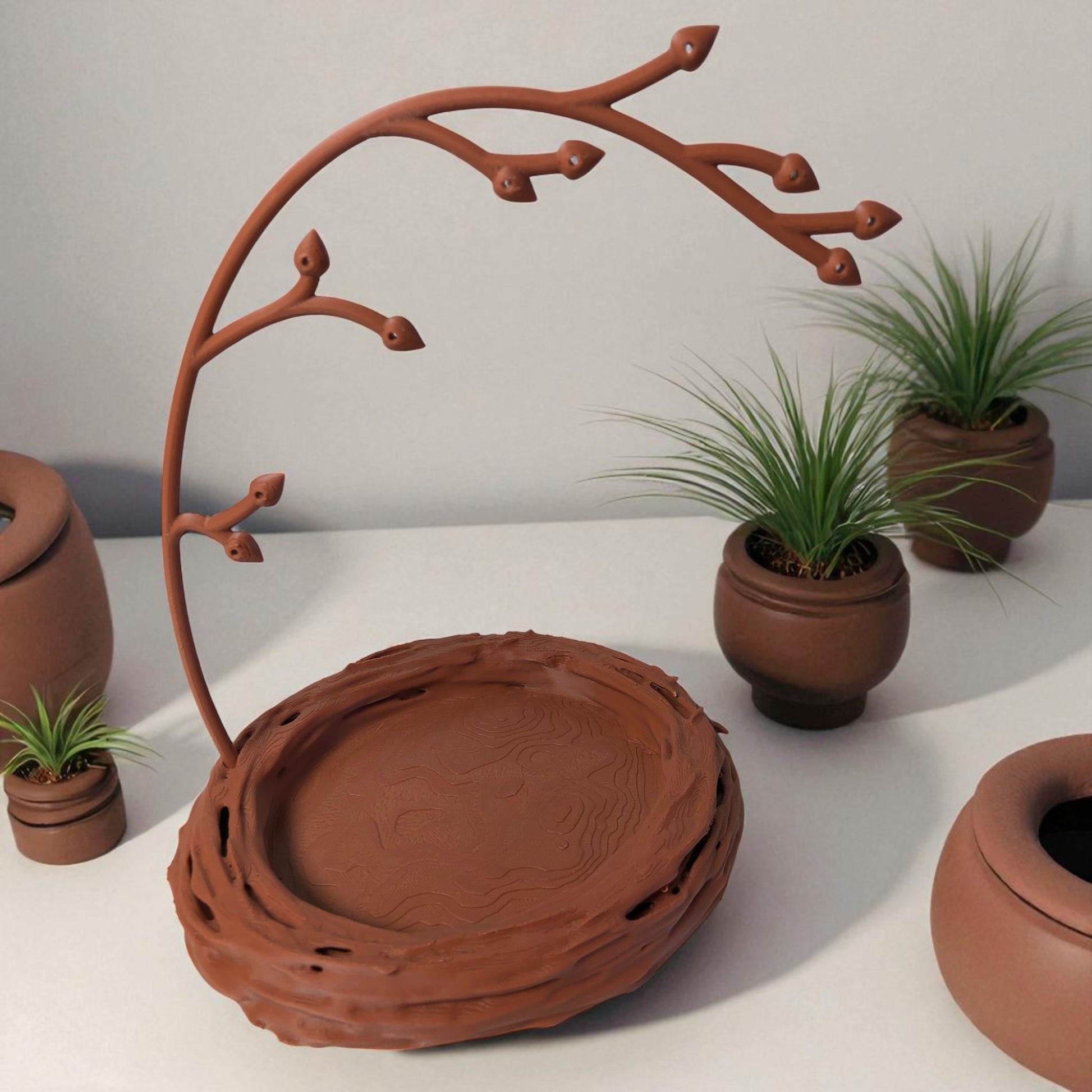 A uniquely designed bird nest jewelry tray with a branch, perfect for organizing rings, earrings, necklaces, and bracelets. The nest-shaped base includes small holes for earring storage, while the branch provides an elegant spot for hanging jewelry. Made from durable, eco-friendly 3D-printed material, this nature-inspired jewelry organizer adds a stylish and functional touch to any vanity or dresser.