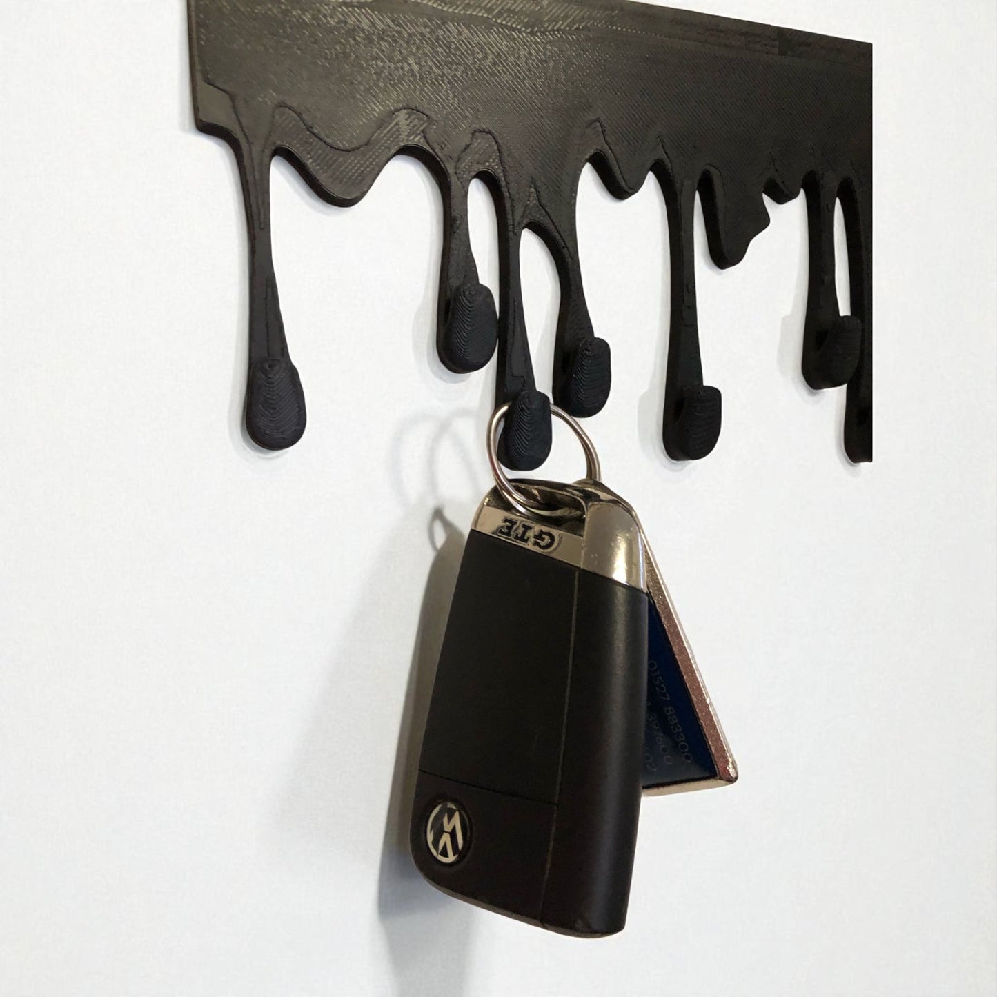 modern dripping key hanger with a unique dripping paint design, available in small (180mm x 90mm) and large (239mm x 120mm) sizes. holds up to 9 key sets and can be mounted with adhesive strips for a rent-friendly option or secured with screws for a permanent installation. a stylish and functional wall-mounted key organizer for homes, apartments, and offices.