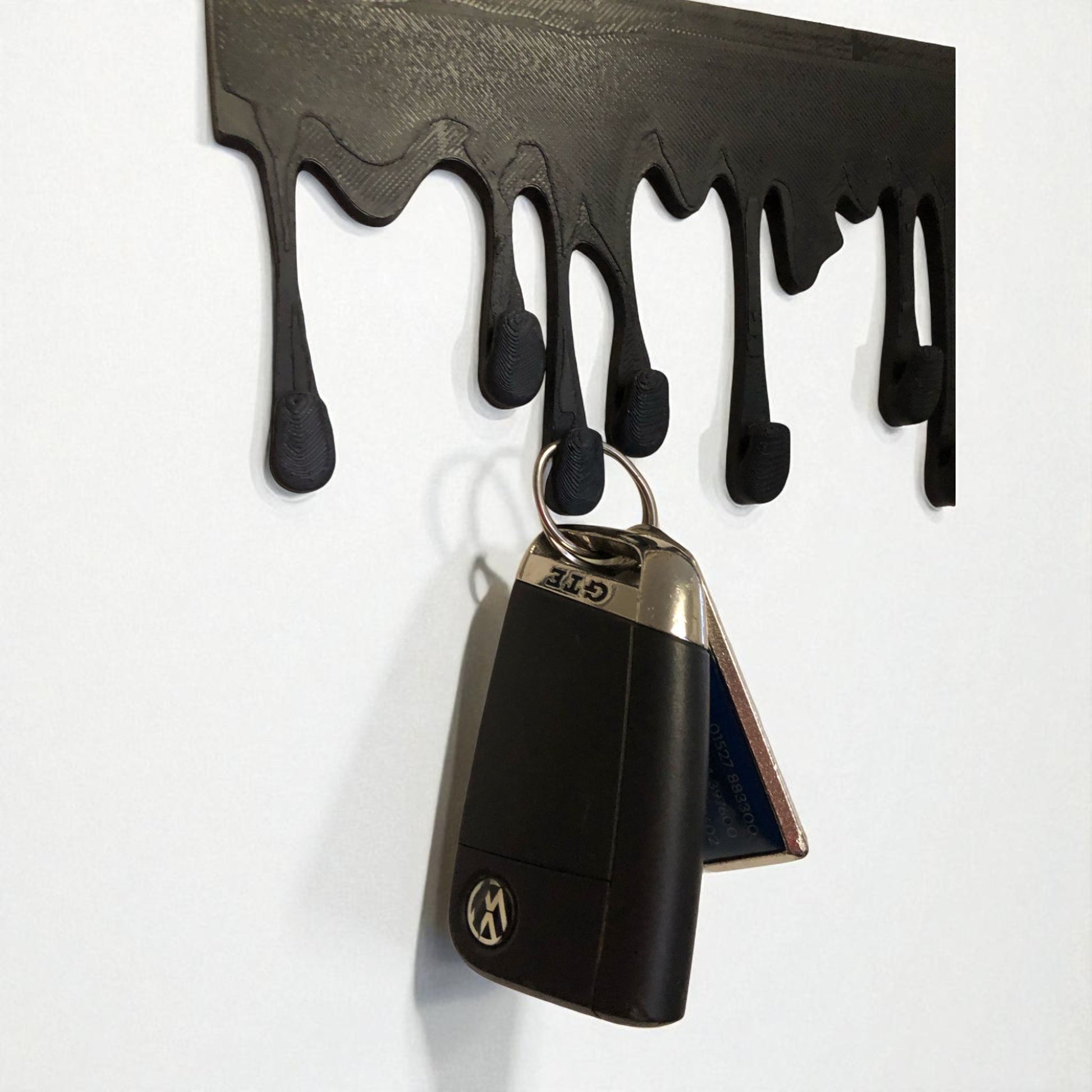 Modern Dripping Key Hanger with a unique dripping paint design, available in small (180mm x 90mm) and large (239mm x 120mm) sizes. Holds up to 9 key sets and can be mounted with adhesive strips for a rent-friendly option or secured with screws for a permanent installation. A stylish and functional wall-mounted key organizer for homes, apartments, and offices.