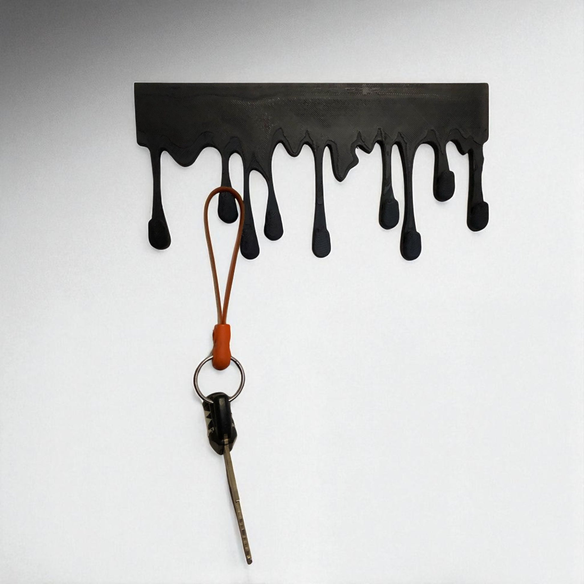 Modern Dripping Key Hanger with a unique dripping paint design, available in small (180mm x 90mm) and large (239mm x 120mm) sizes. Holds up to 9 key sets and can be mounted with adhesive strips for a rent-friendly option or secured with screws for a permanent installation. A stylish and functional wall-mounted key organizer for homes, apartments, and offices.