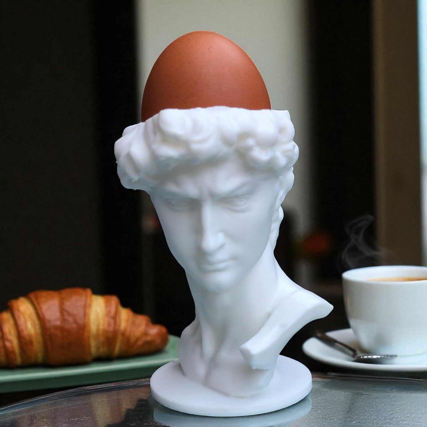 3d printed male bust egg cup in classical sculpture style, featuring a hollowed head holding a boiled egg. unique breakfast decor piece in white pla, perfect for easter table settings or artistic kitchen gifts.