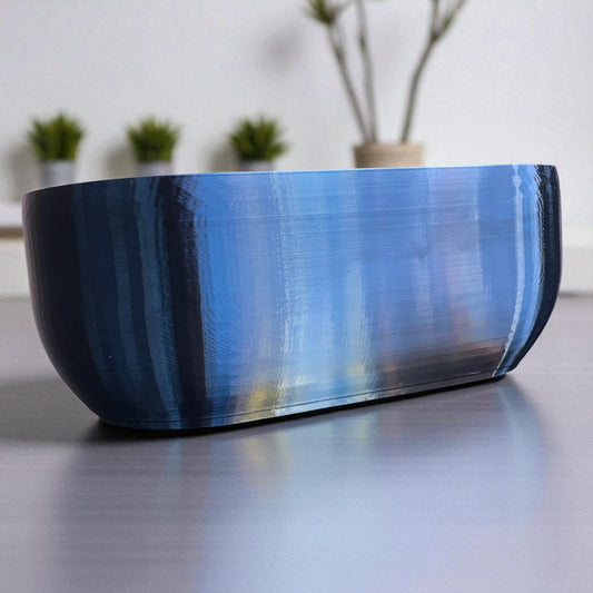 Modern rectangular wall planter with rounded corners, mounted on a wall and planted with fresh herbs like parsley, coriander, and basil. The large 3D printed planter is shown in use indoors, highlighting its sleek design and easy wall-mount installation with screws or tape