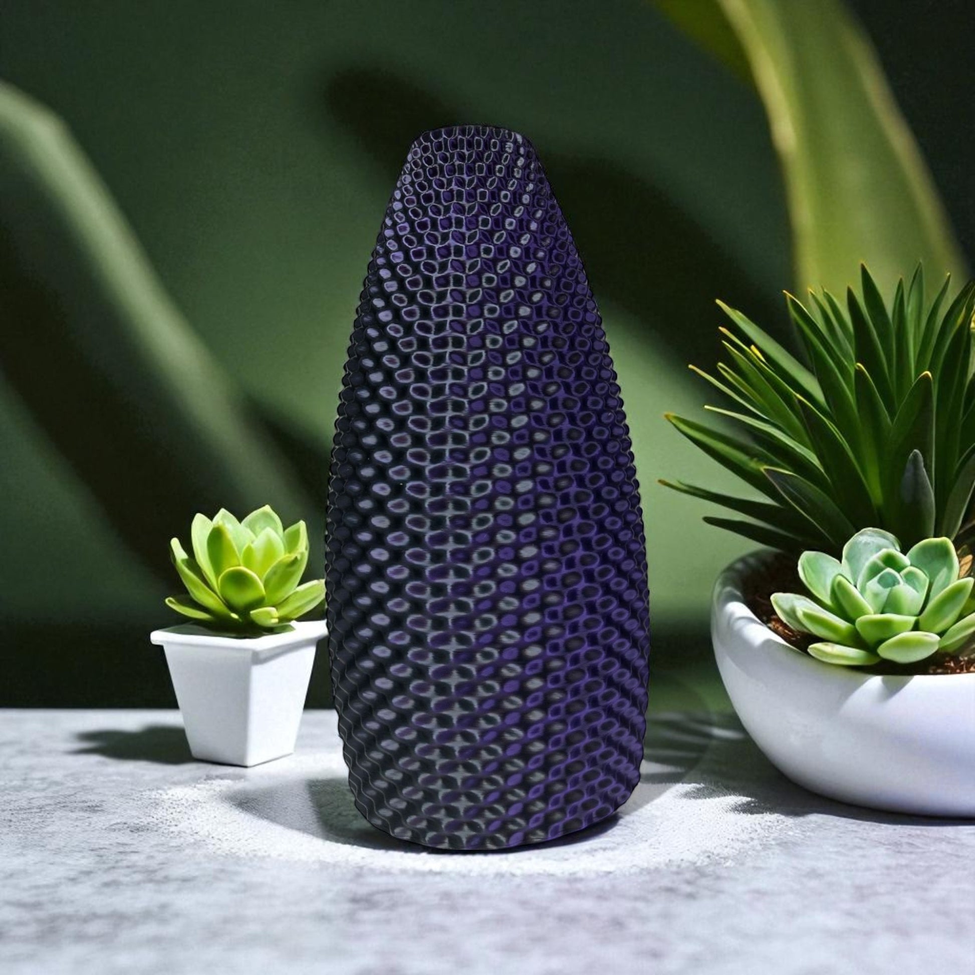 Textured purple vase with green plants in the background