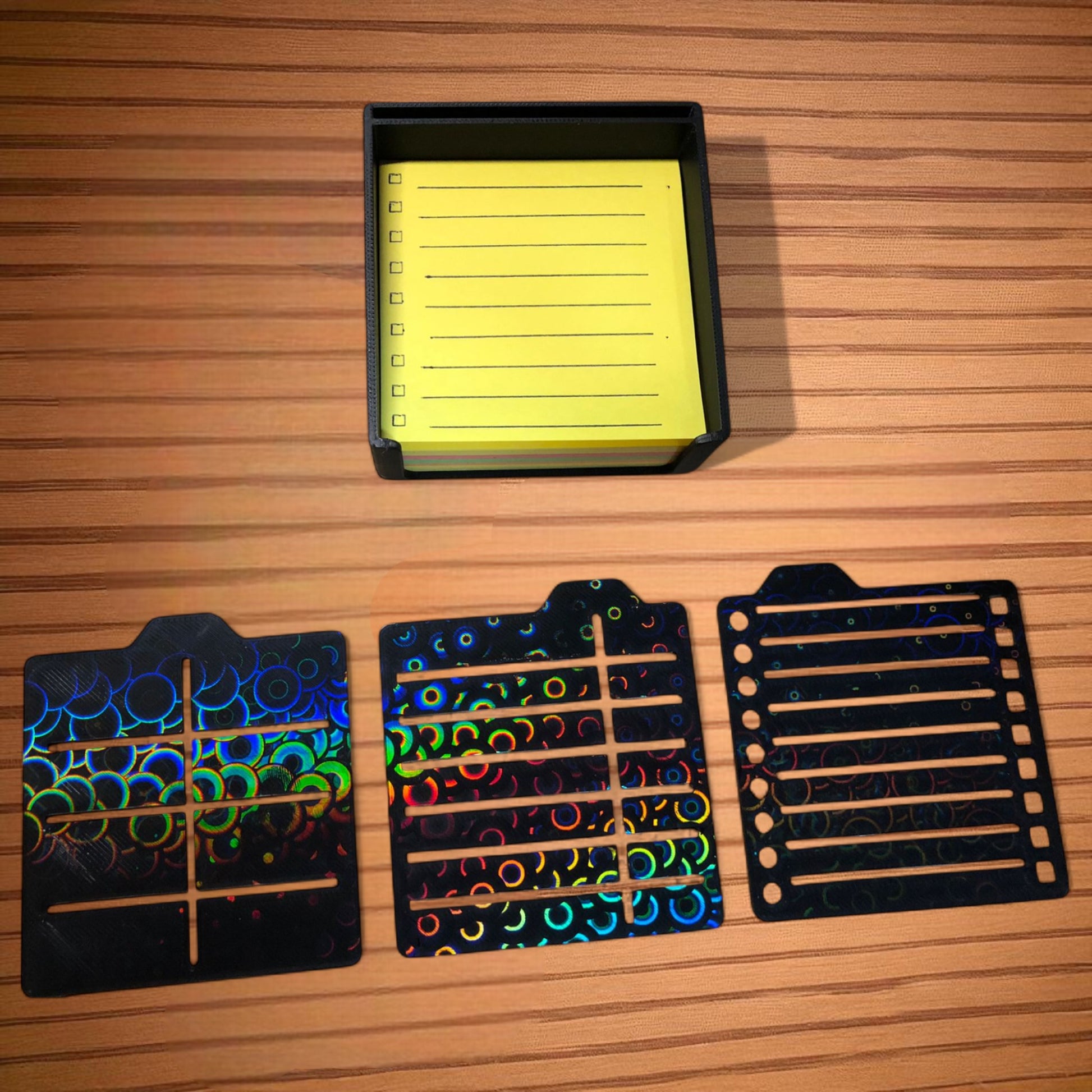 Sticky note holder with colorful sticky notes and three reusable stencils, designed for organizing notes and boosting productivity at a work desk