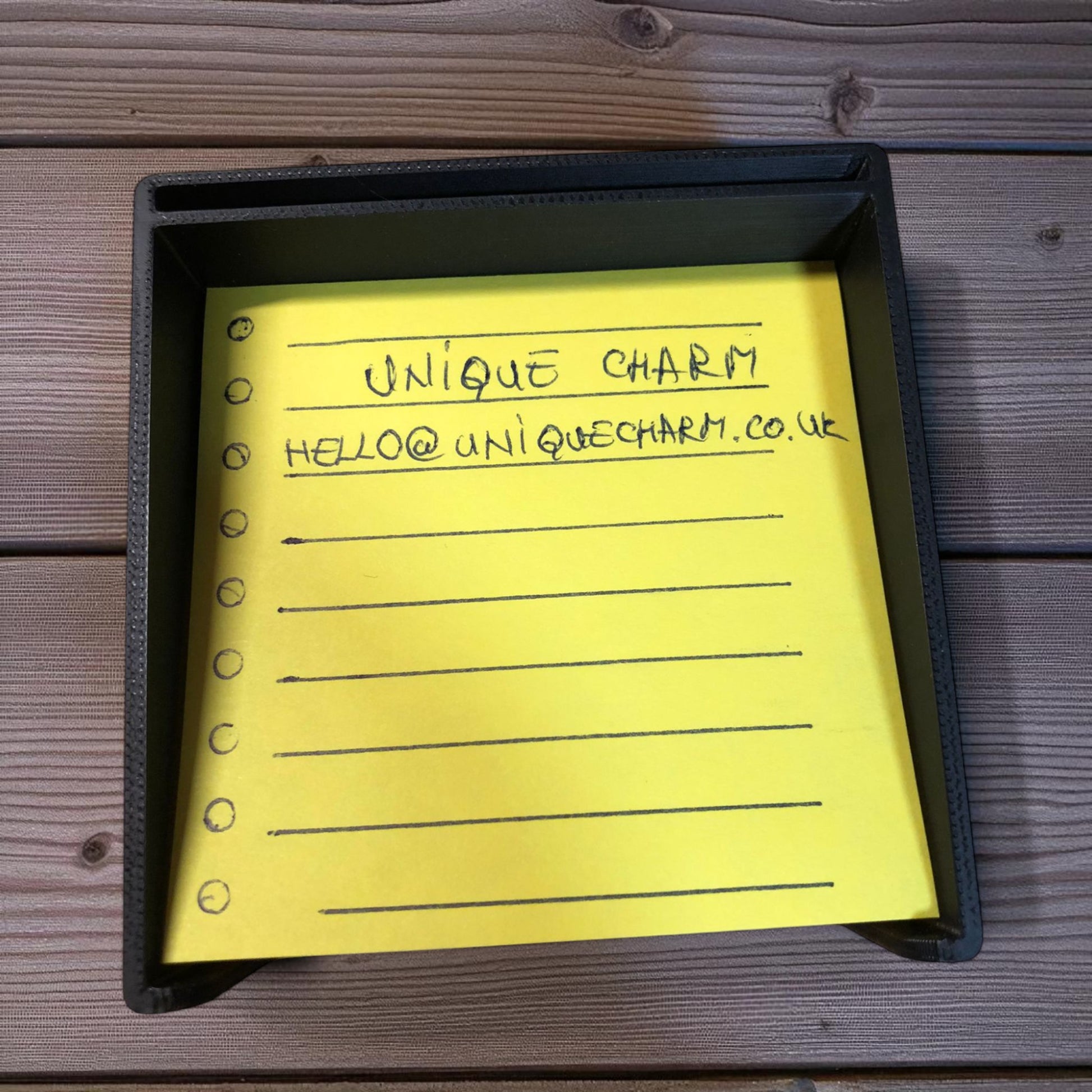 Sticky note holder with colorful sticky notes and three reusable stencils, designed for organizing notes and boosting productivity at a work desk