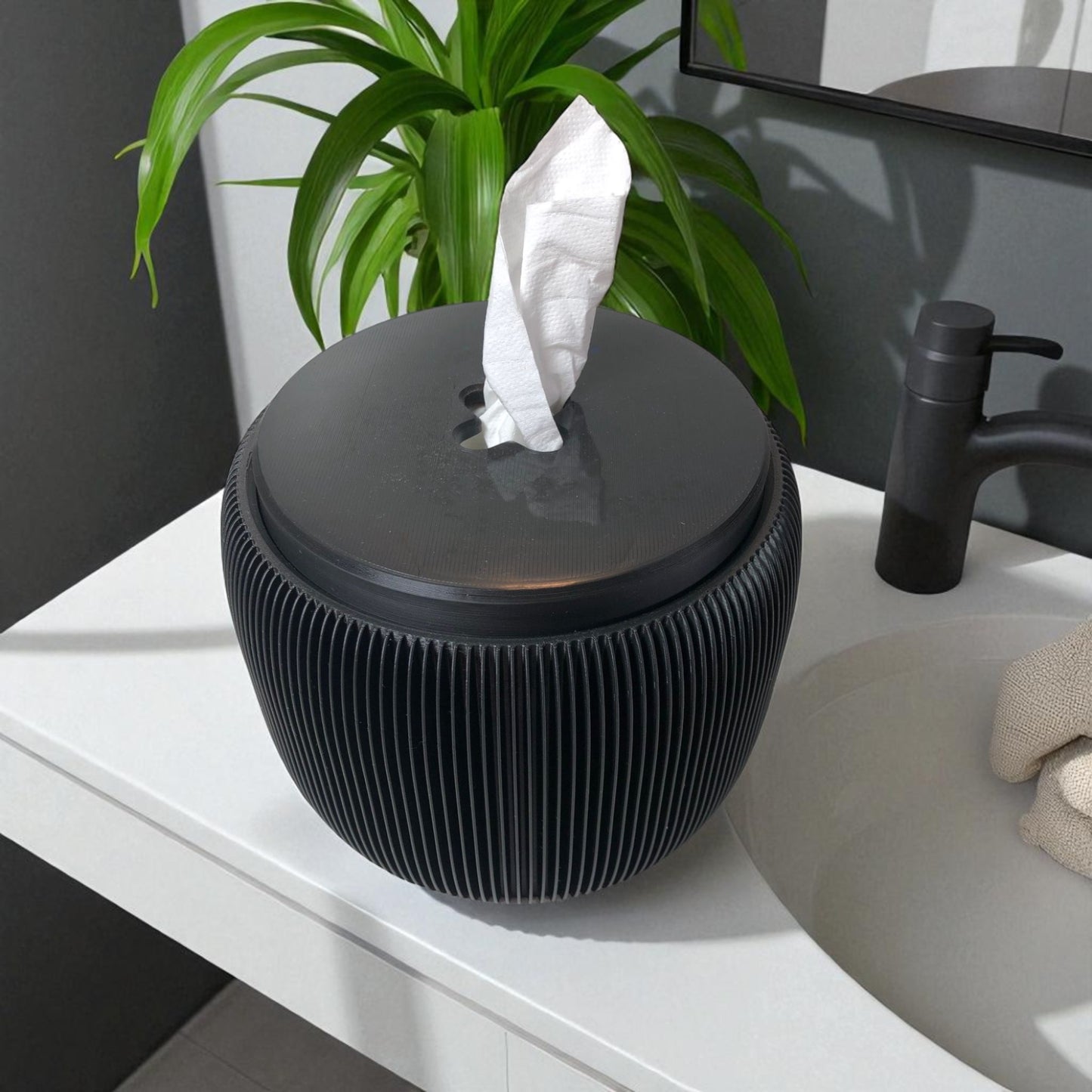 modern black toilet paper holder with ribbed texture and lid, designed to prevent pets or children from unrolling the paper. stylish and compact bathroom accessory shown on a white surface.