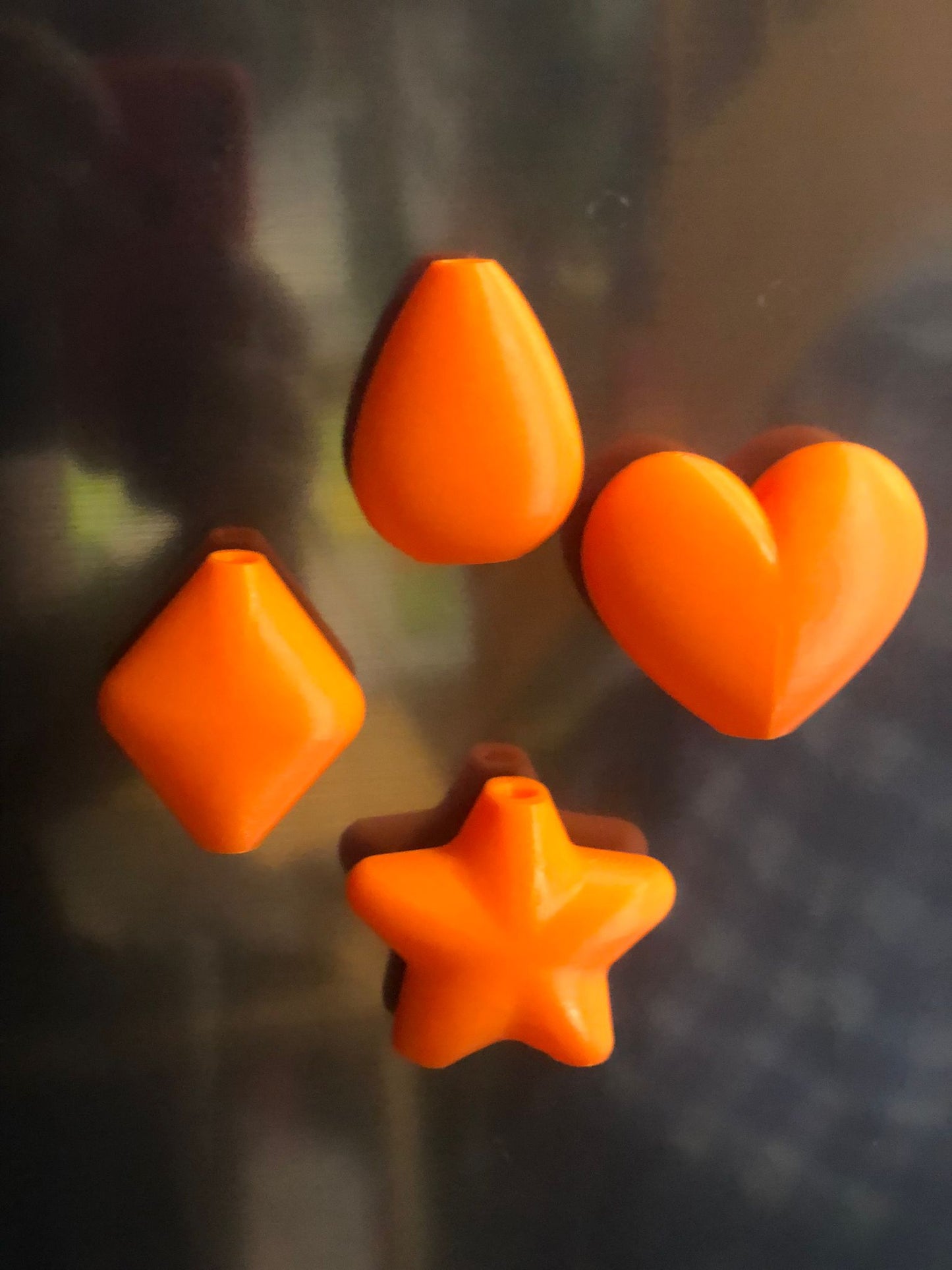 set of mini magnetic vases in heart, star, diamond, and teardrop shapes, attached to a refrigerator and holding small colorful flowers, displayed in red and white colors.