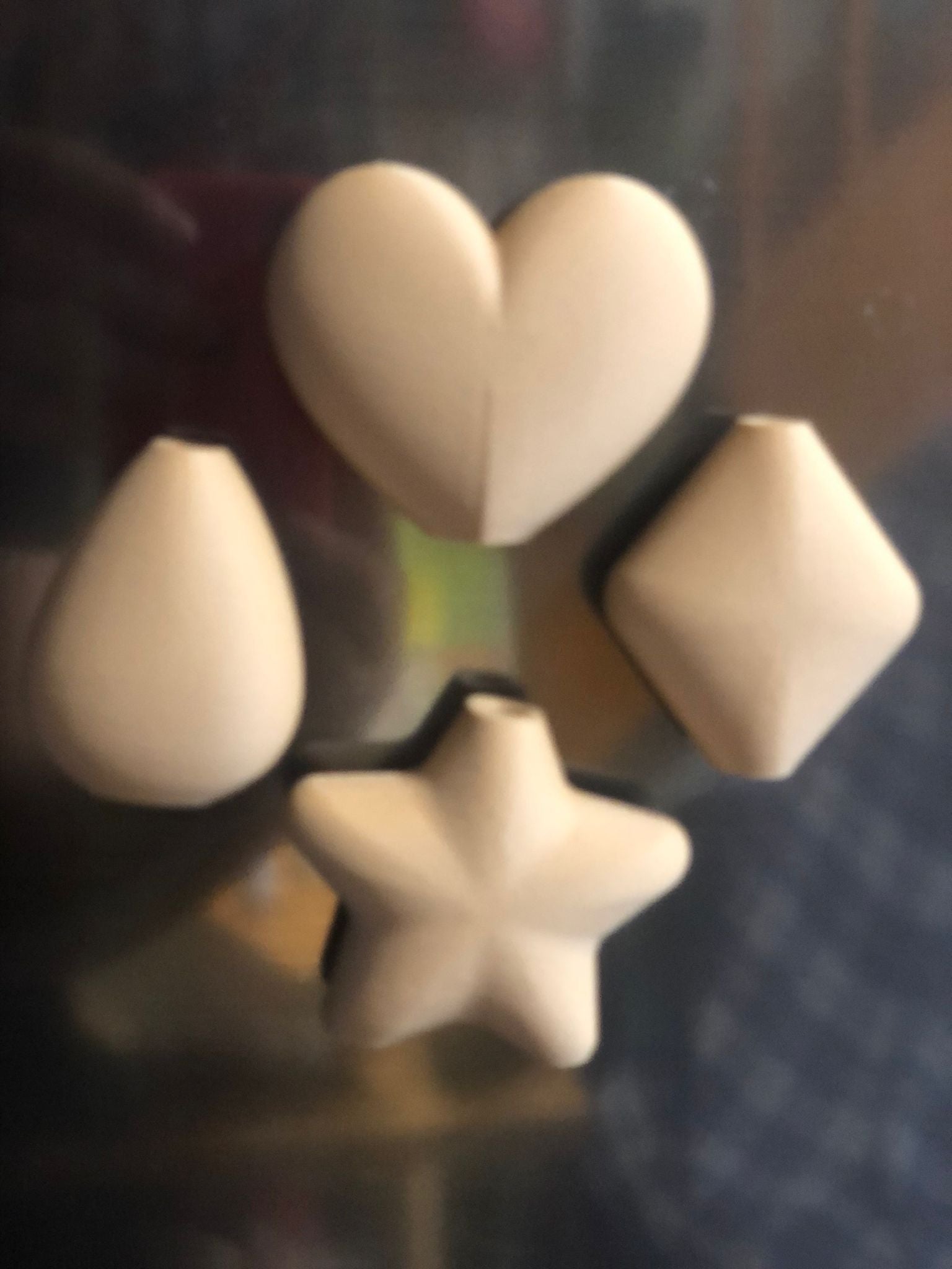 Set of mini magnetic vases in heart, star, diamond, and teardrop shapes, attached to a refrigerator and holding small colorful flowers, displayed in red and white colors.