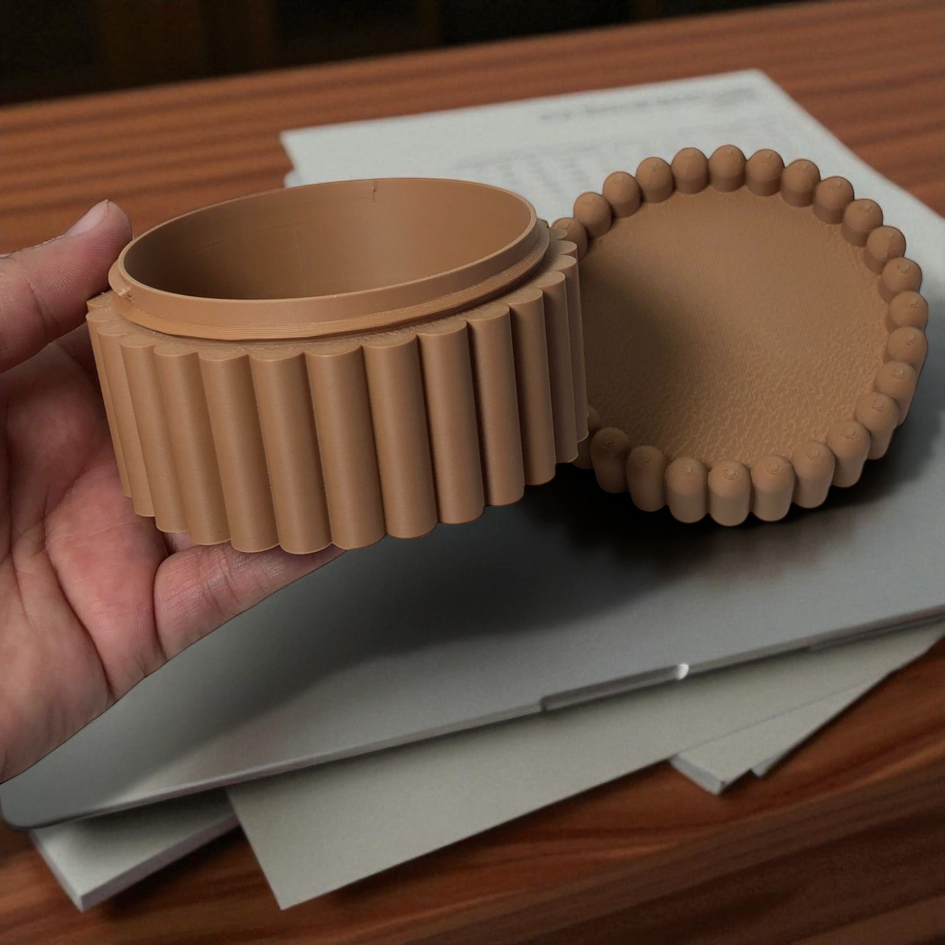 3D printed macaron-style jar with a rounded lid and ribbed cookie-like sides, shown in brown and pink colors, used for vanity or bathroom storage.
