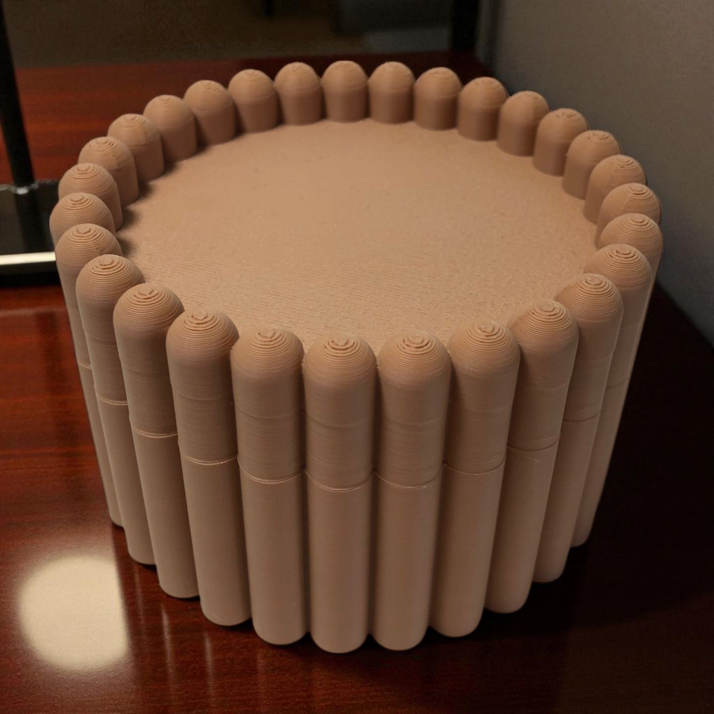3d printed macaron-style jar with a rounded lid and ribbed cookie-like sides, shown in brown and pink colors, used for vanity or bathroom storage.