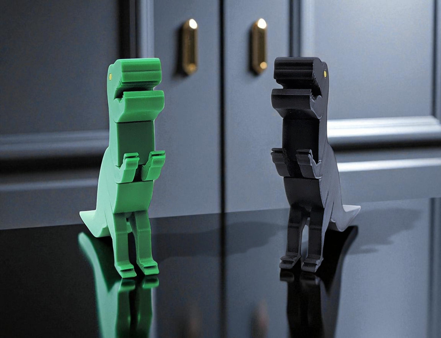 green and black dinosaur-shaped objects on a reflective surface with a gray background