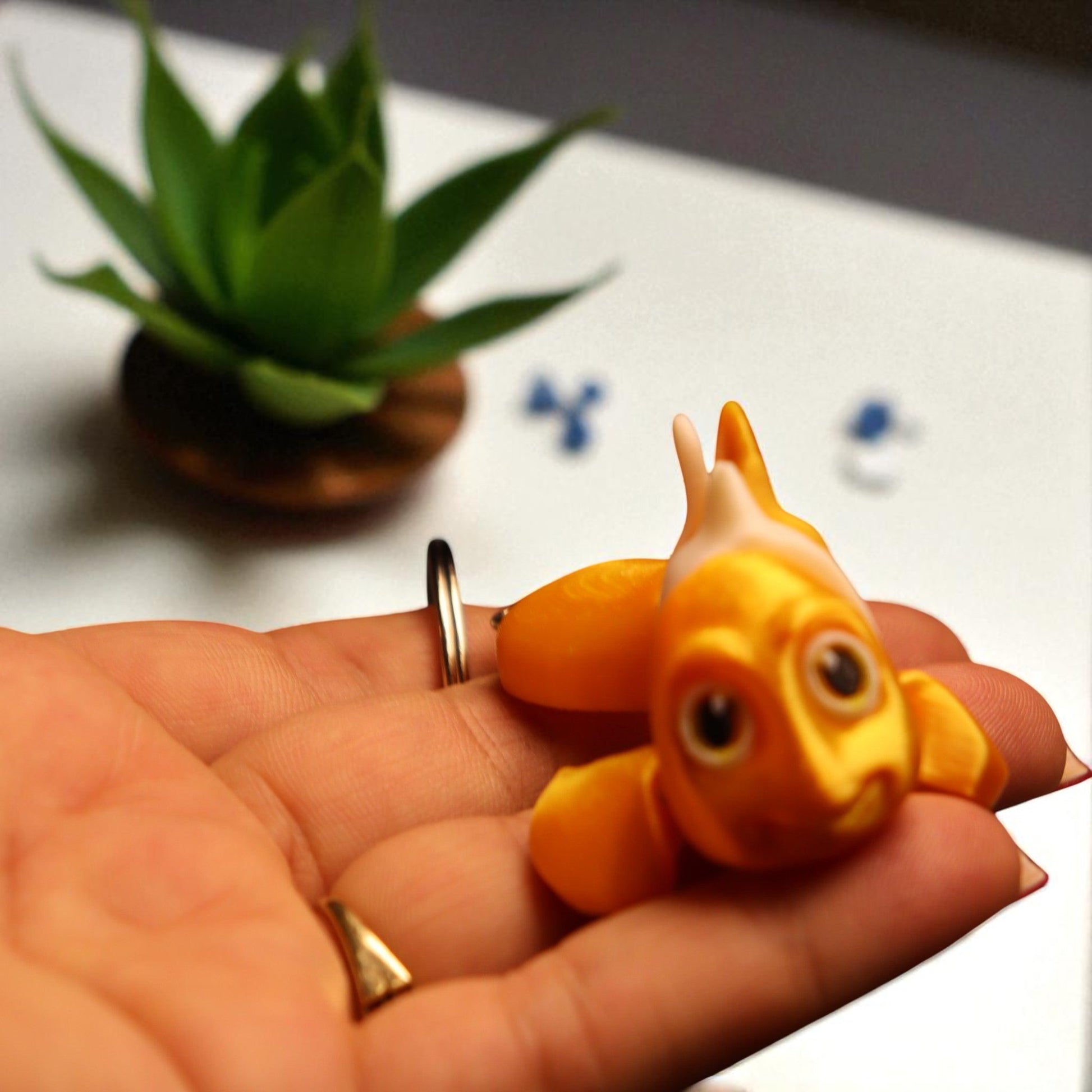 3D printed articulated clown fish toy in vibrant two-tone colors, featuring a cute face and flexible, lifelike movement, perfect as a keychain or playful ocean-themed gift.