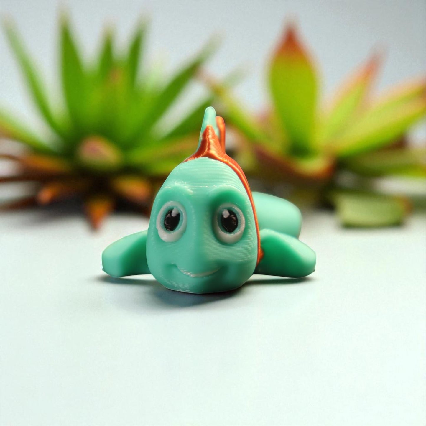 3d printed articulated clown fish toy in vibrant two-tone colors, featuring a cute face and flexible, lifelike movement, perfect as a keychain or playful ocean-themed gift.
