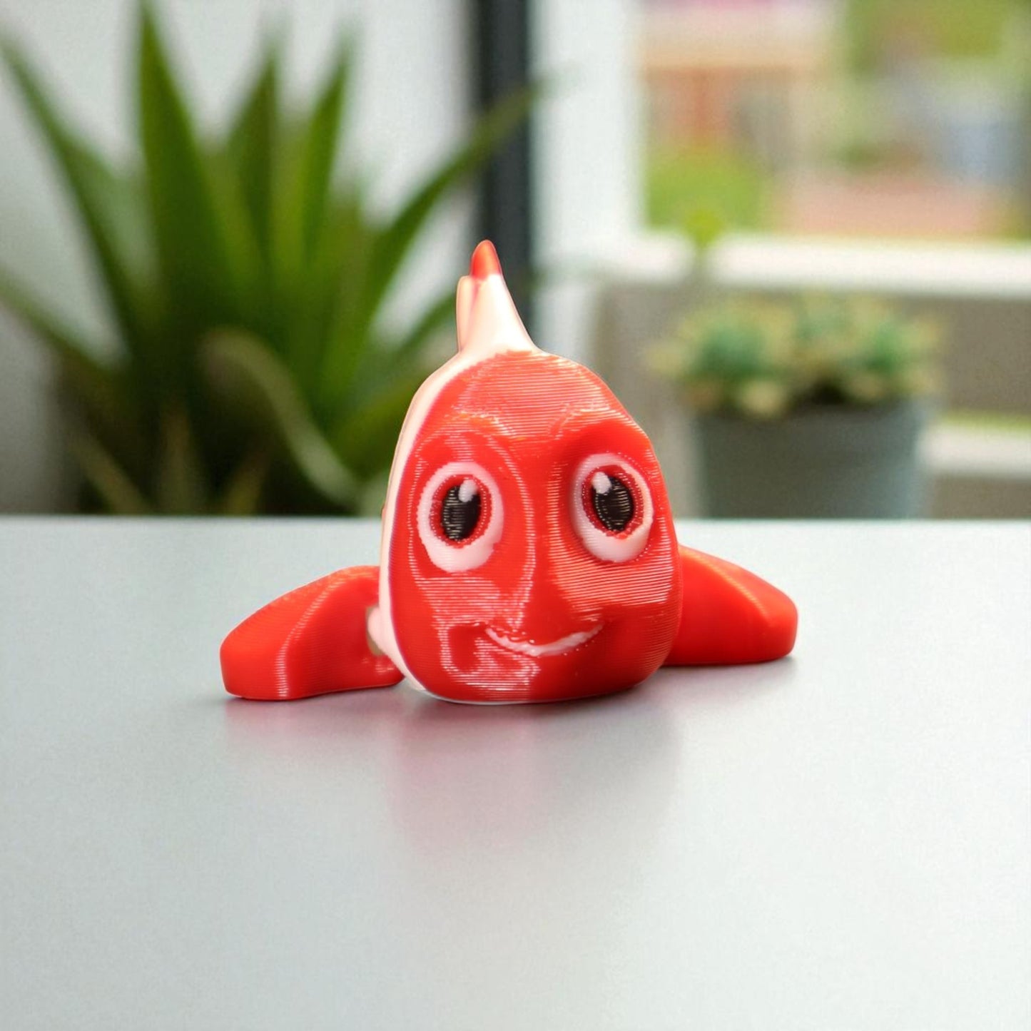 3d printed articulated clown fish toy in vibrant two-tone colors, featuring a cute face and flexible, lifelike movement, perfect as a keychain or playful ocean-themed gift.