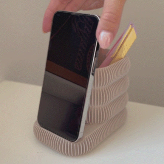 Multifunctional phone stand with an integrated cup holder for brushes, pens, or markers. Made from durable 3D-printed material, this sleek and compact design keeps your essentials organized while holding your phone at the perfect viewing angle. Ideal for desks, makeup stations, or creative workspaces.