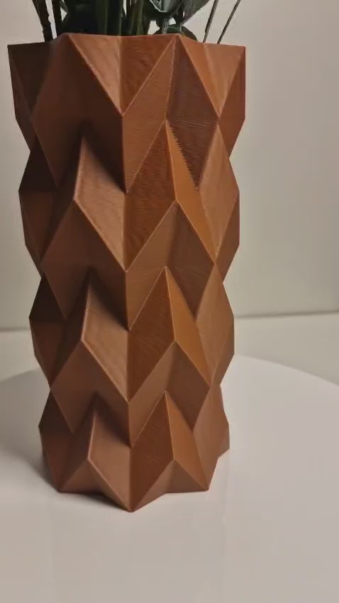 A modern 3D-printed vase with a sleek, sculptural design. Made from durable, waterproof material, this stylish vase is perfect for fresh flowers, dried arrangements, or as a standalone decor piece. Ideal for contemporary and minimalist interiors.