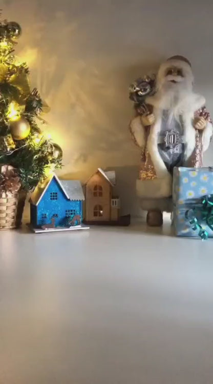 White Christmas reindeer and pine tree LED tealight decoration glowing on table, festive holiday décor for mantel or centerpiece.